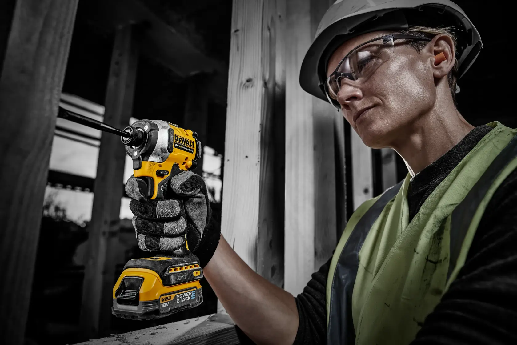 Worker using a DEWALT tool powered by DCBP034 battery at a construction site, face blurred for privacy.
