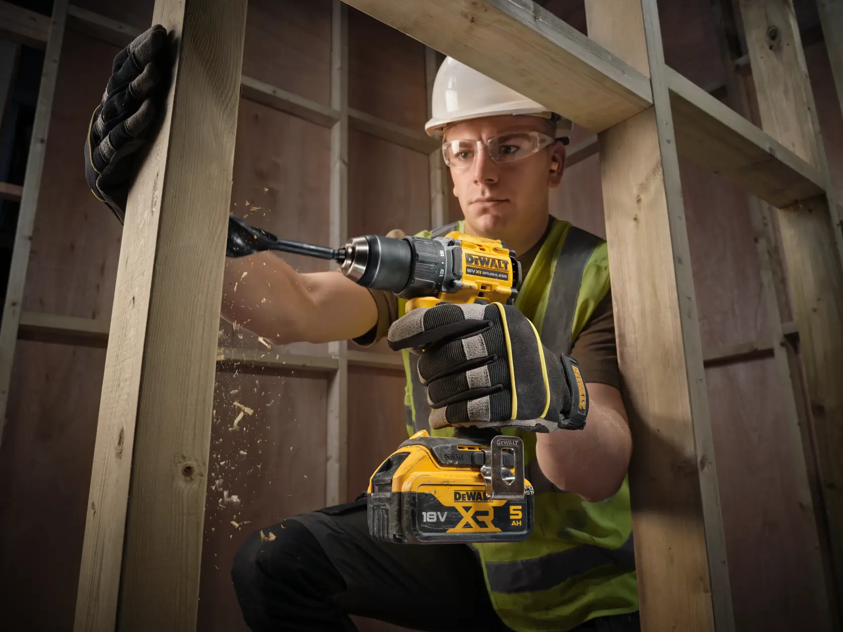 DEWALT drill in use, wood construction. SKUs: DCD794P2T, DCD794P2T-QW. Worker in gloves, blurred face.