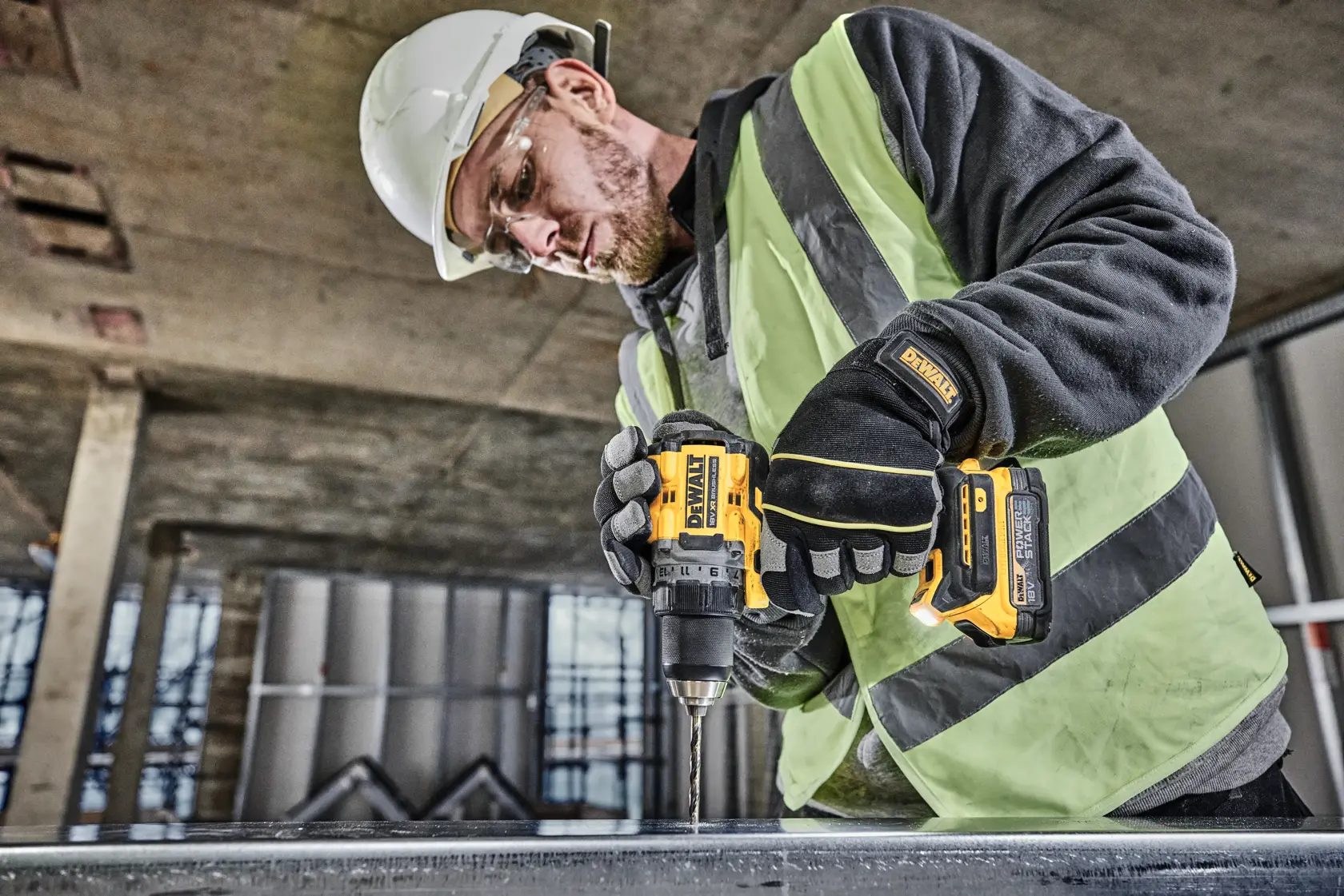 Trapano a batteria DEWALT 18V XR brushless con batteria POWERSTACK, vista laterale.