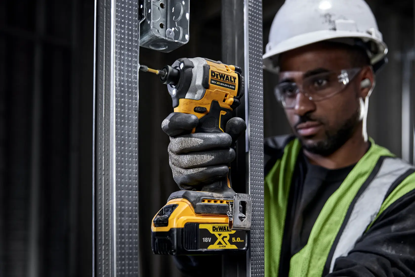 DEWALT tool in use. Visible DCF850N, DCZ2050P2T-XE, DCZ401P3-XE. Worker with glove, hard hat, safety vest.
