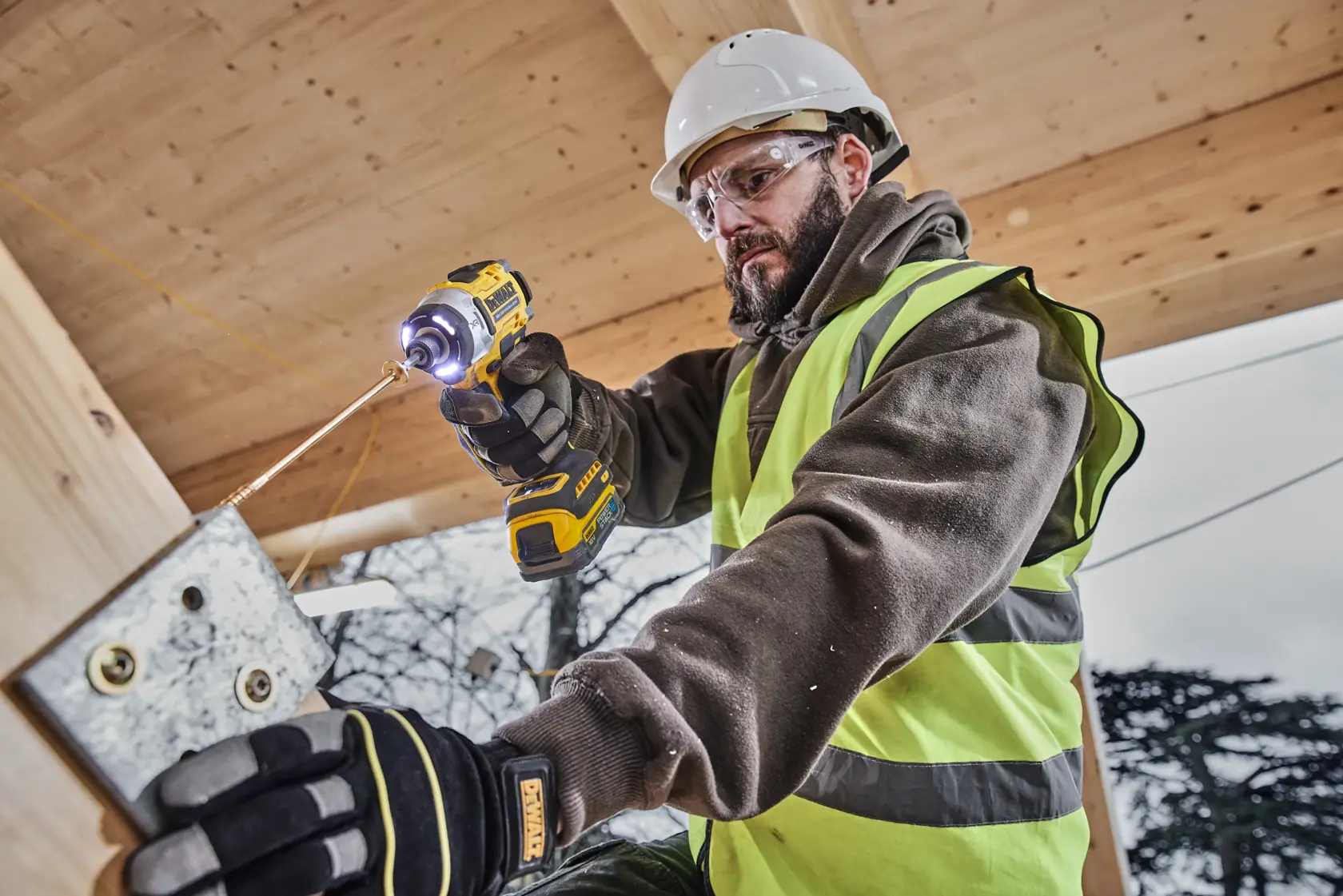 Operaio usa DEWALT DCK2201P1T1-XE, DCF860NT trapano in cantiere. Categoria fotografia.