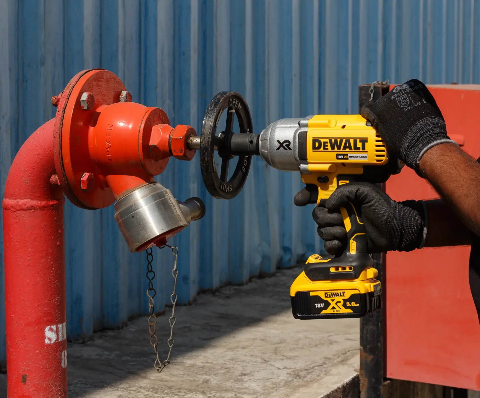 Persona usa avvitatore a impulsi DEWALT per stringere i bulloni di una ruota auto.