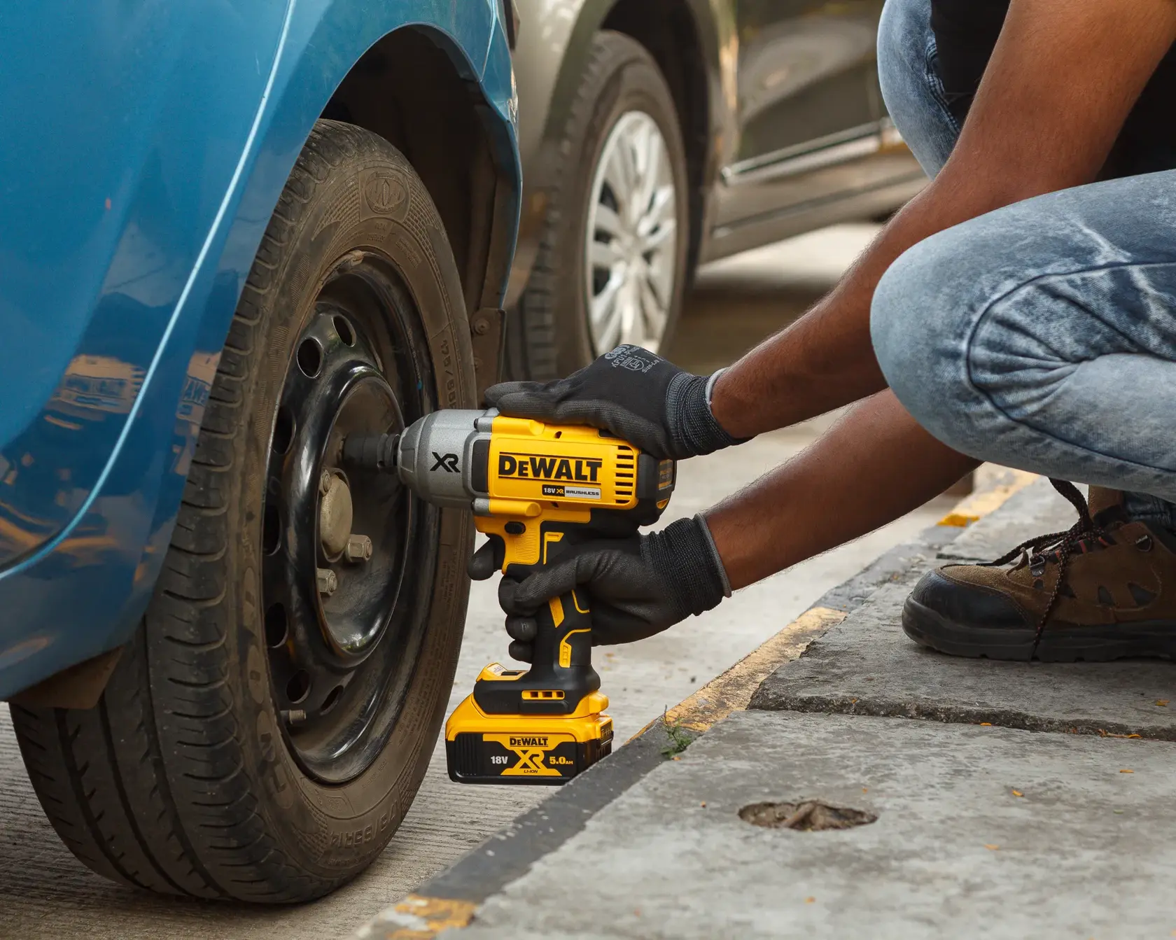 A black hard plastic carrying case containing a DEWALT cordless impact wrench, two rechargeable batteries, and a battery charger, arranged neatly inside.