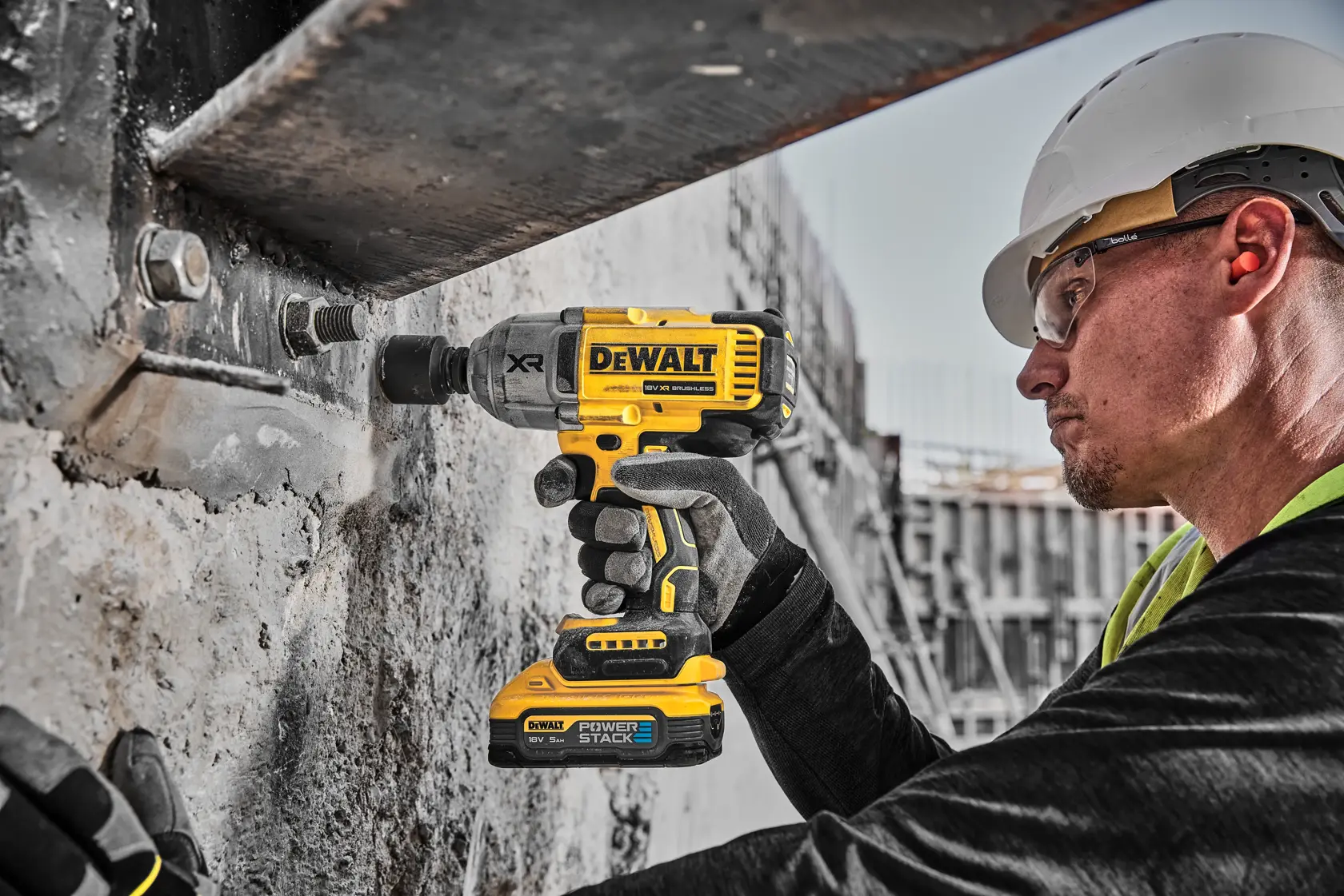 A DEWALT 18V XR cordless impact wrench with brushless motor and POWERSTACK 5Ah battery, shown in yellow and black with silver metallic front.