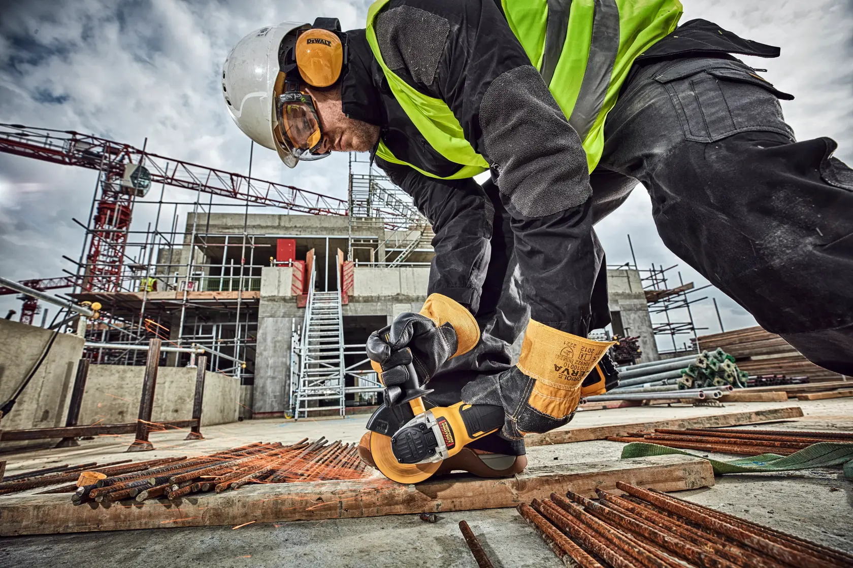 Worker using DEWALT tool on site. SKUs: DCG406N, DCZ409P2-XE, DCZ401P3-XE, DCG406. Photography category.