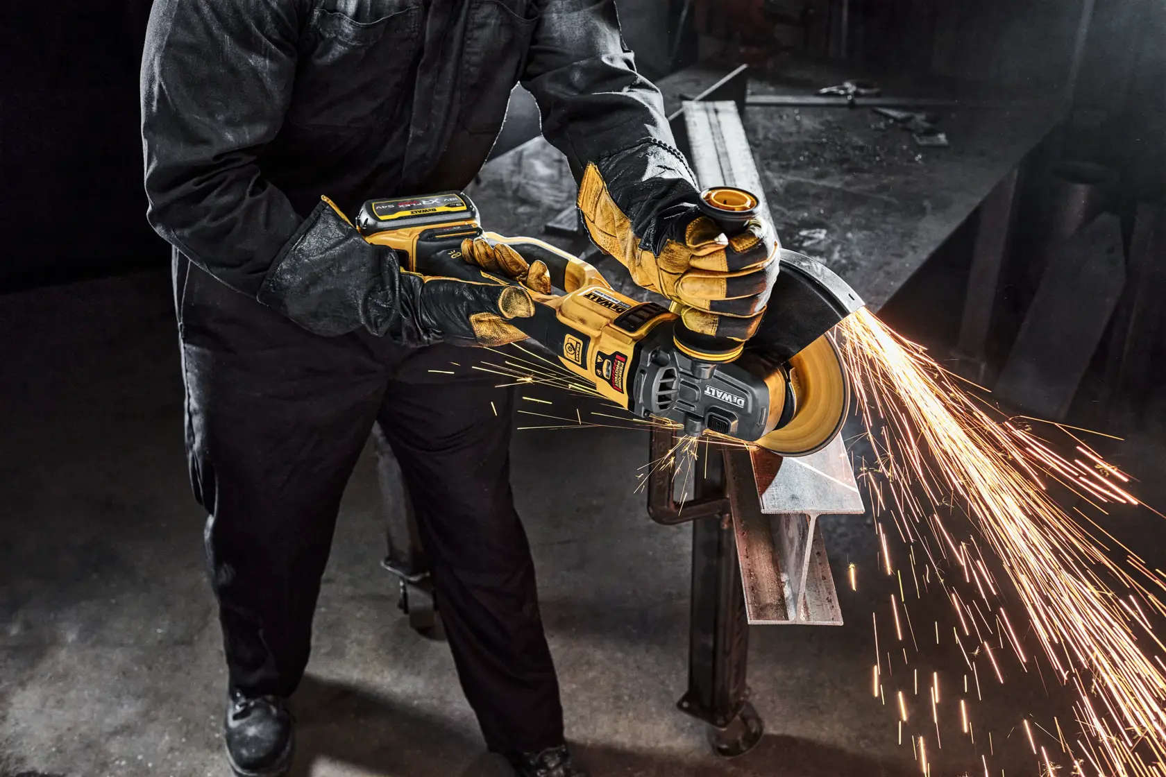 Person uses DEWALT cordless grinder, producing bright sparks while working on metal in industrial setting.