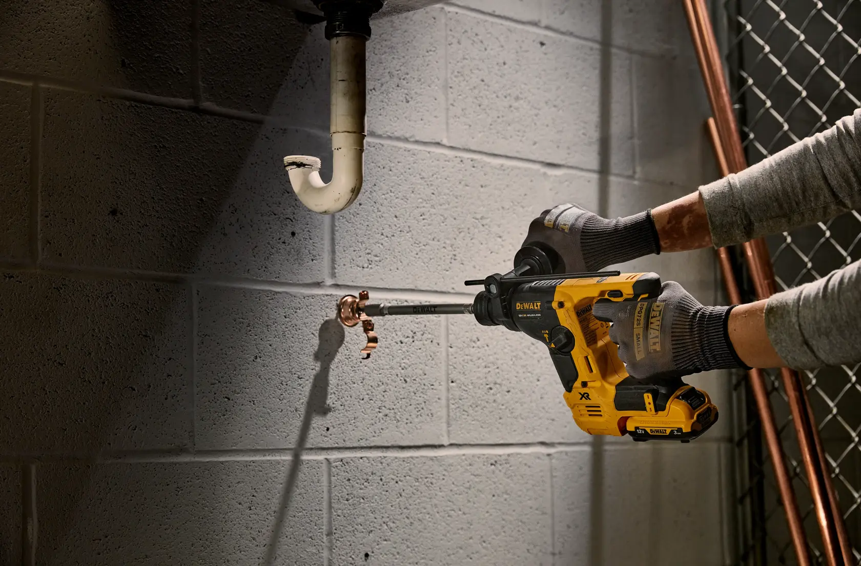 DEWALT tool in use drilling pipe. SKUs: DCH072NT, DCH072N, DCH072N-XJ. Product category: Photography.
