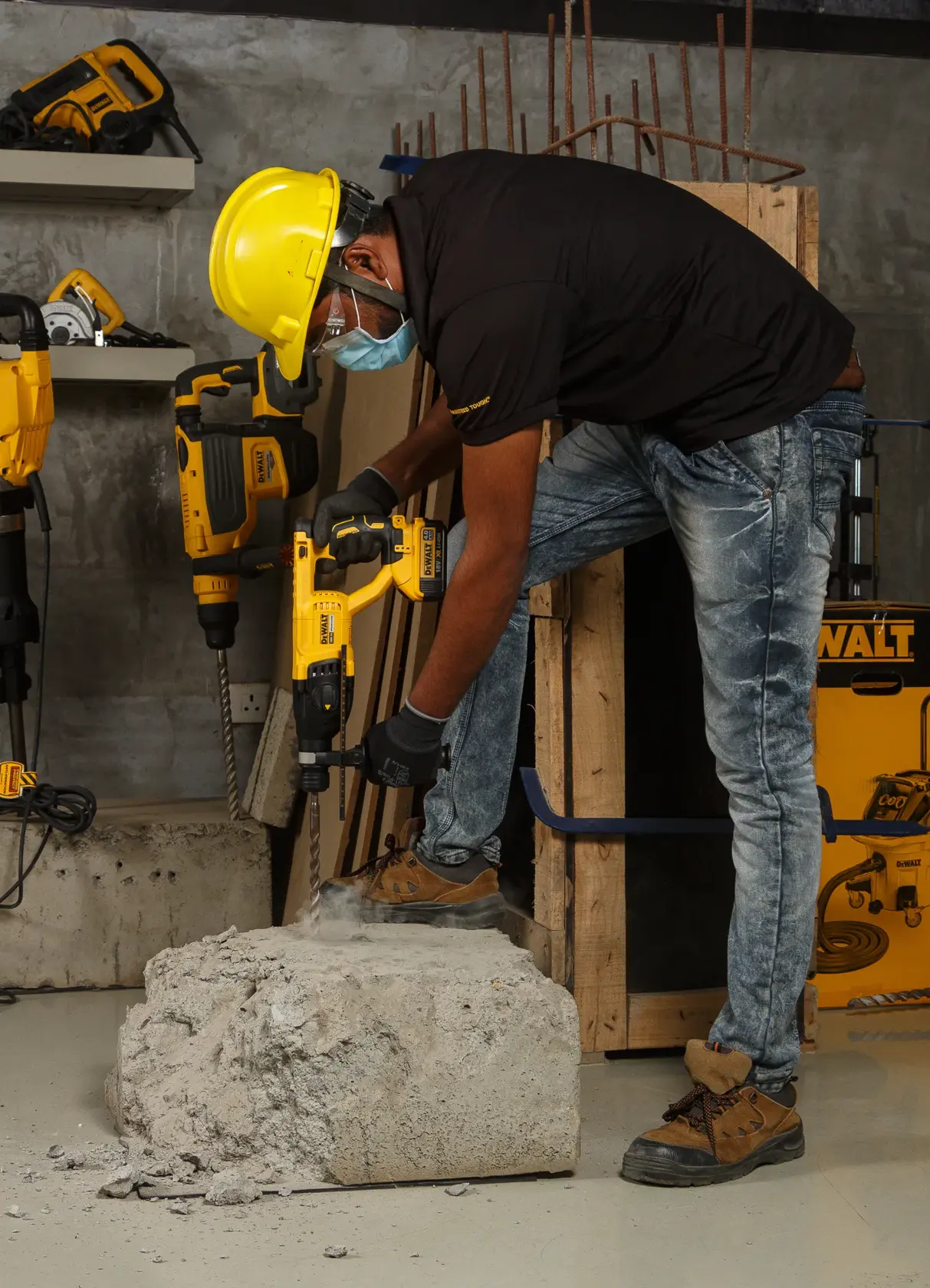 Ouvrier perce du béton avec une perceuse DEWALT DCH133NT, équipé de protections sur chantier.