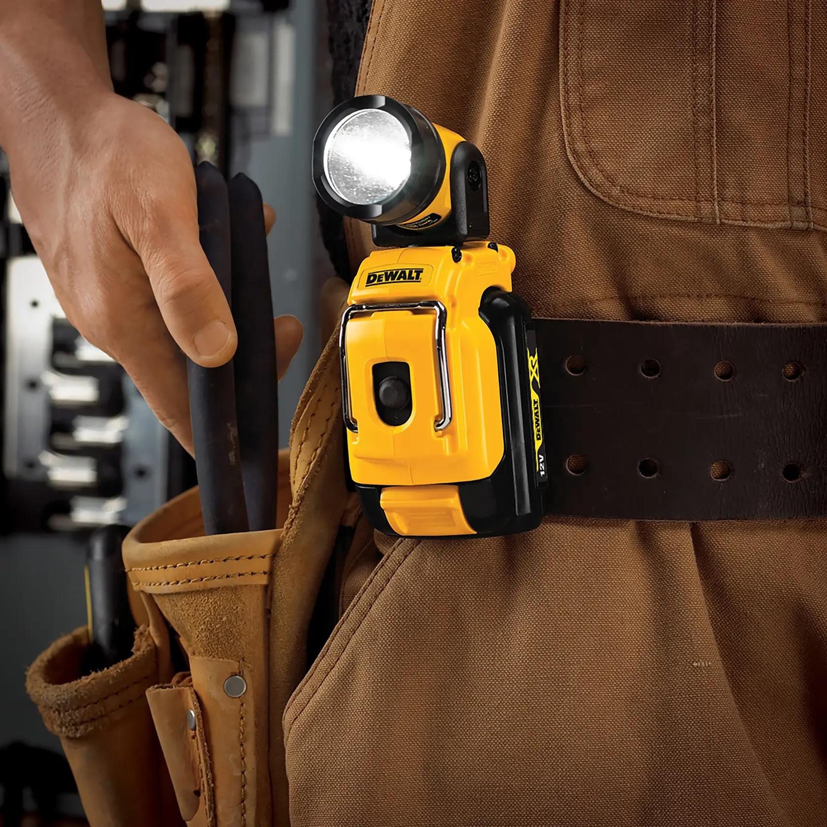DEWALT DCL510N LED work light attached to a tool belt worn by a person in a brown work outfit.