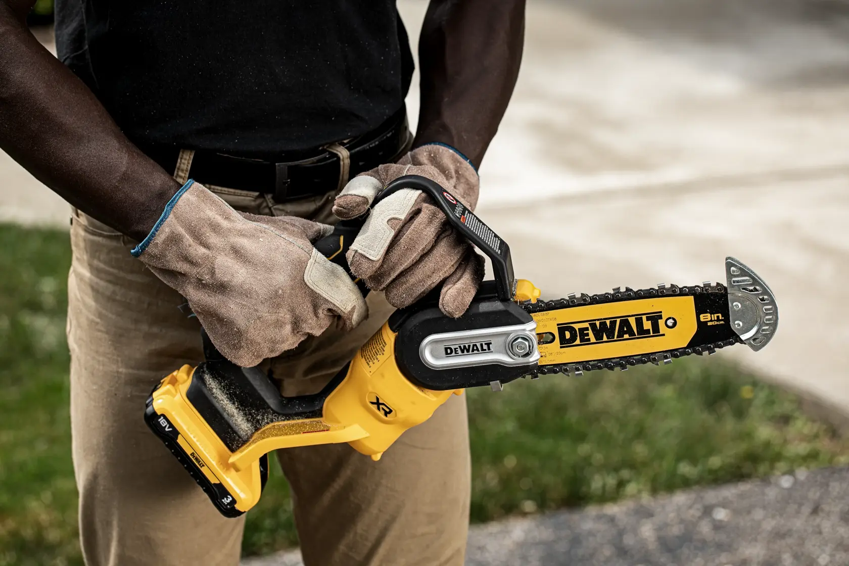 A DEWALT 18V XR Brushless cordless pruner chainsaw featuring a yellow and black design, a safety guard over the chain, and a 5.0Ah lithium-ion battery attached.