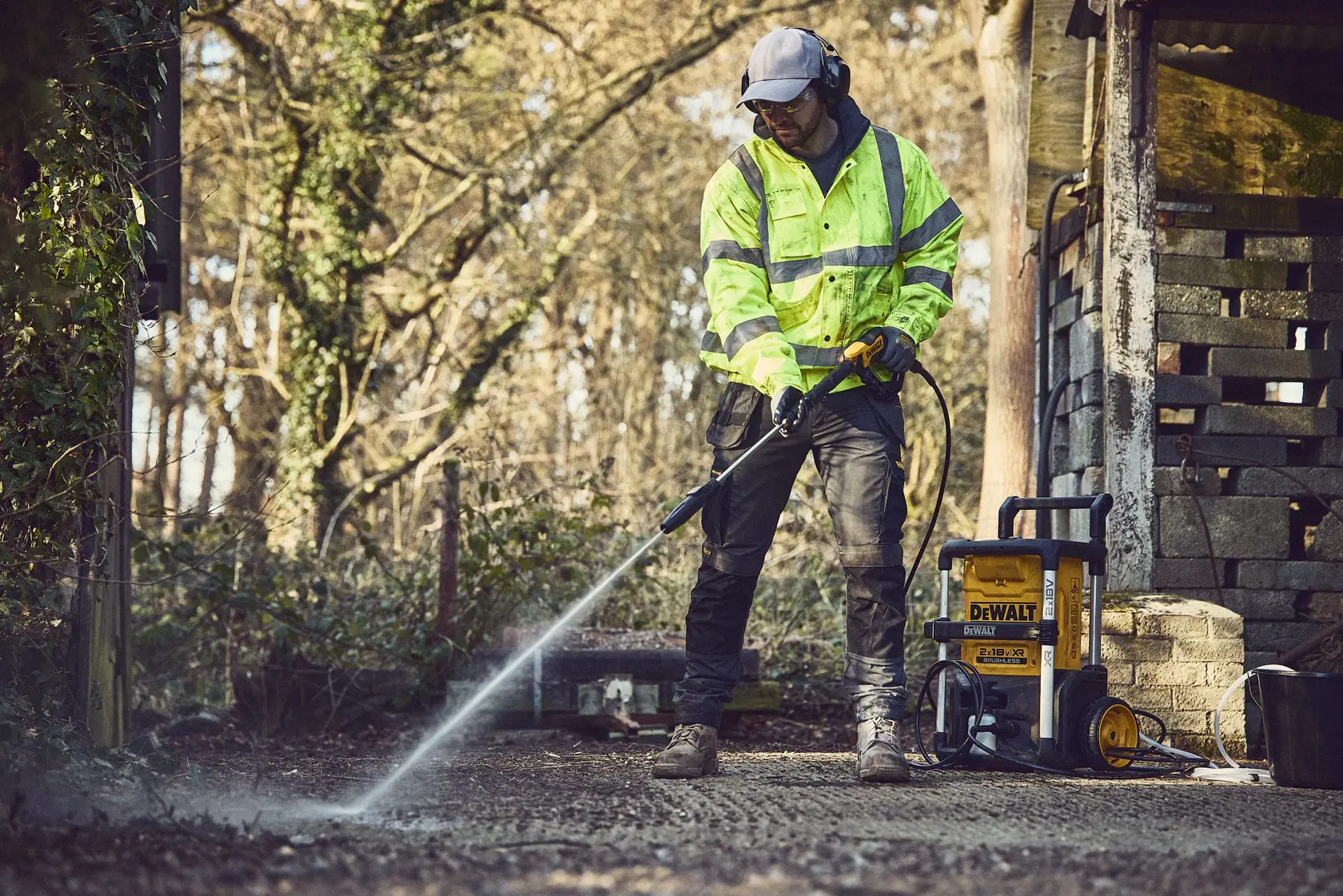DEWALT portable pressure washer, model DCMPW1600, featuring a yellow and black design, large wheels for easy transport, a hose wrapped around the front, and an ergonomic handle.