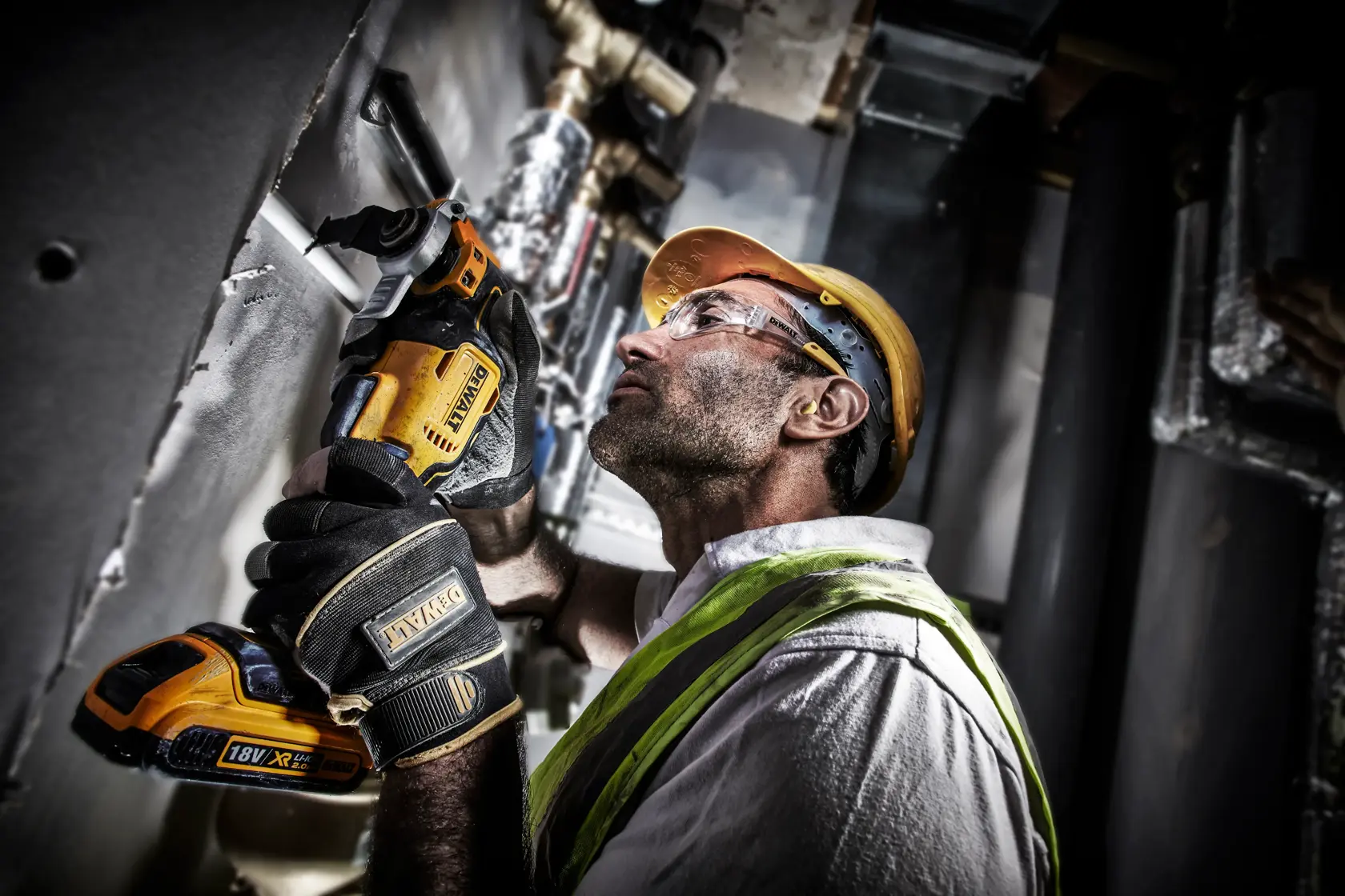 Worker uses a DEWALT DCS356NT cordless tool on a construction site, wearing gloves and a safety helmet.