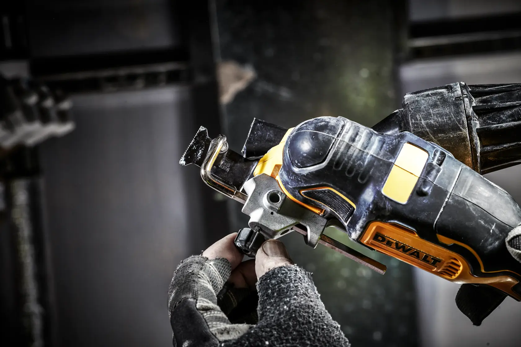 Close-up of a DEWALT DCS356N power tool in use, held by a gloved hand during a work task.