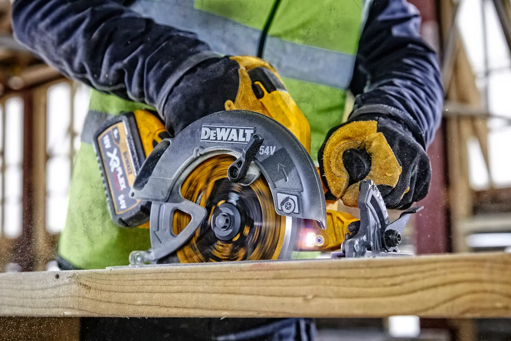 DEWALT cordless circular saw cutting wood, held by gloved hands in a construction setting.