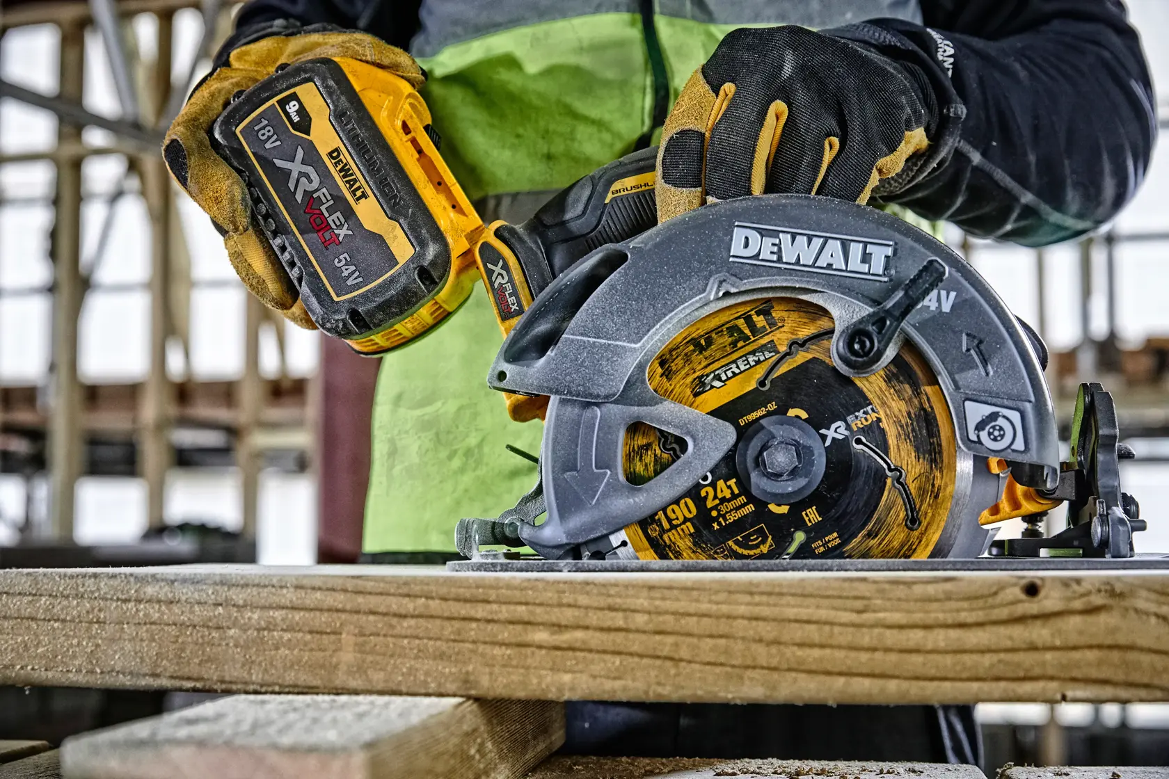 Worker uses DEWALT cordless circular saw to cut wood. The saw has a yellow XR FLEXVOLT battery attached.