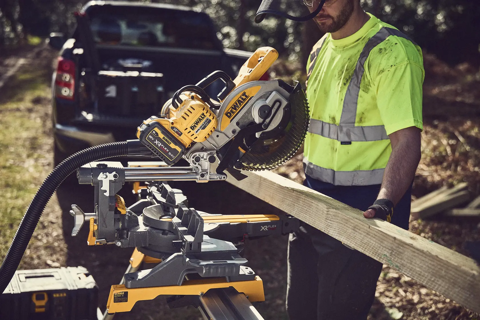 DEWALT DCS727N saw in use on-site, cutting wood by a worker in a safety vest outdoors near a vehicle.