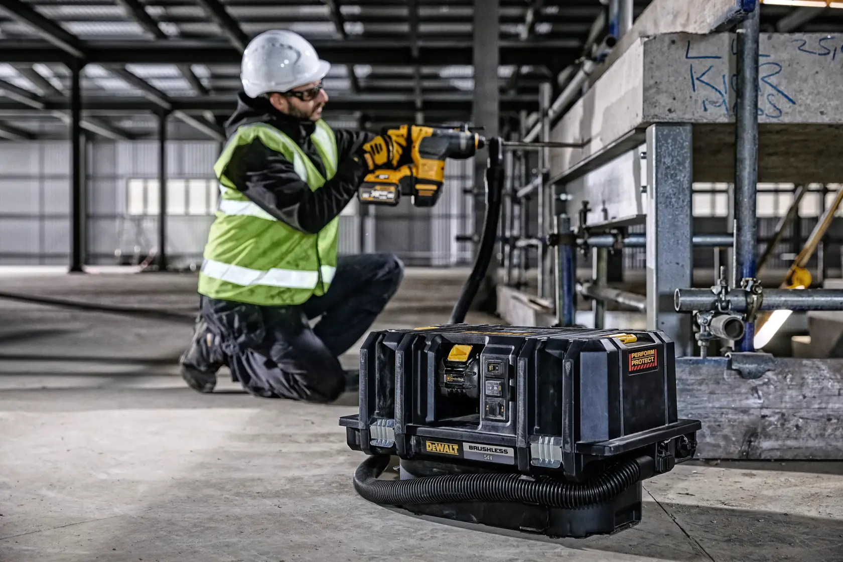 DEWALT DCV586MT2 dust extractor on construction site, worker using DEWALT tool and wearing safety gear.