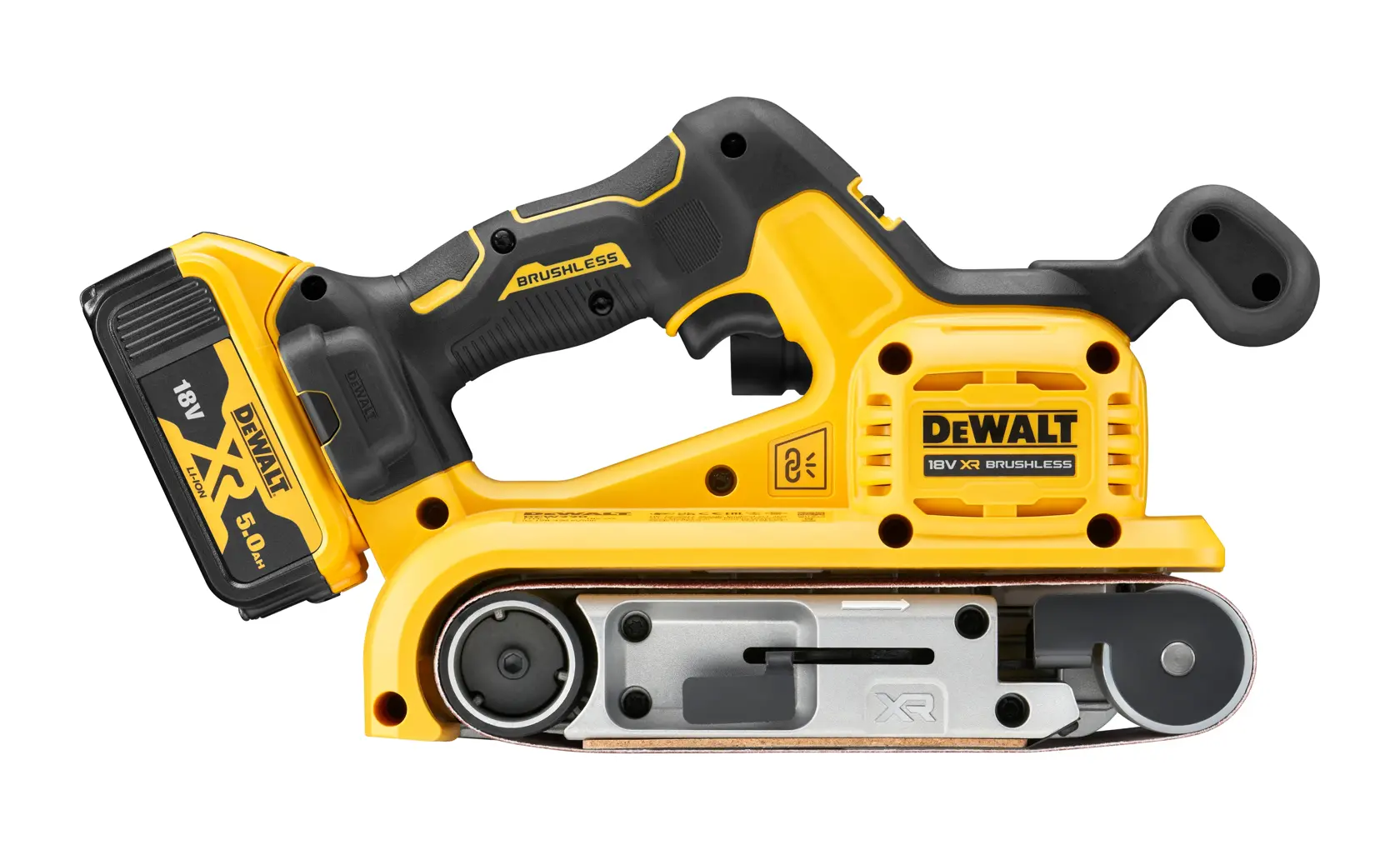En person bruker en DEWALT batteridrevet båndslipemaskin (SKU: DCW220P2) på et trestykke i et verksted. Personen har på seg vernebriller og forkle, og ansiktet er uskarpt.