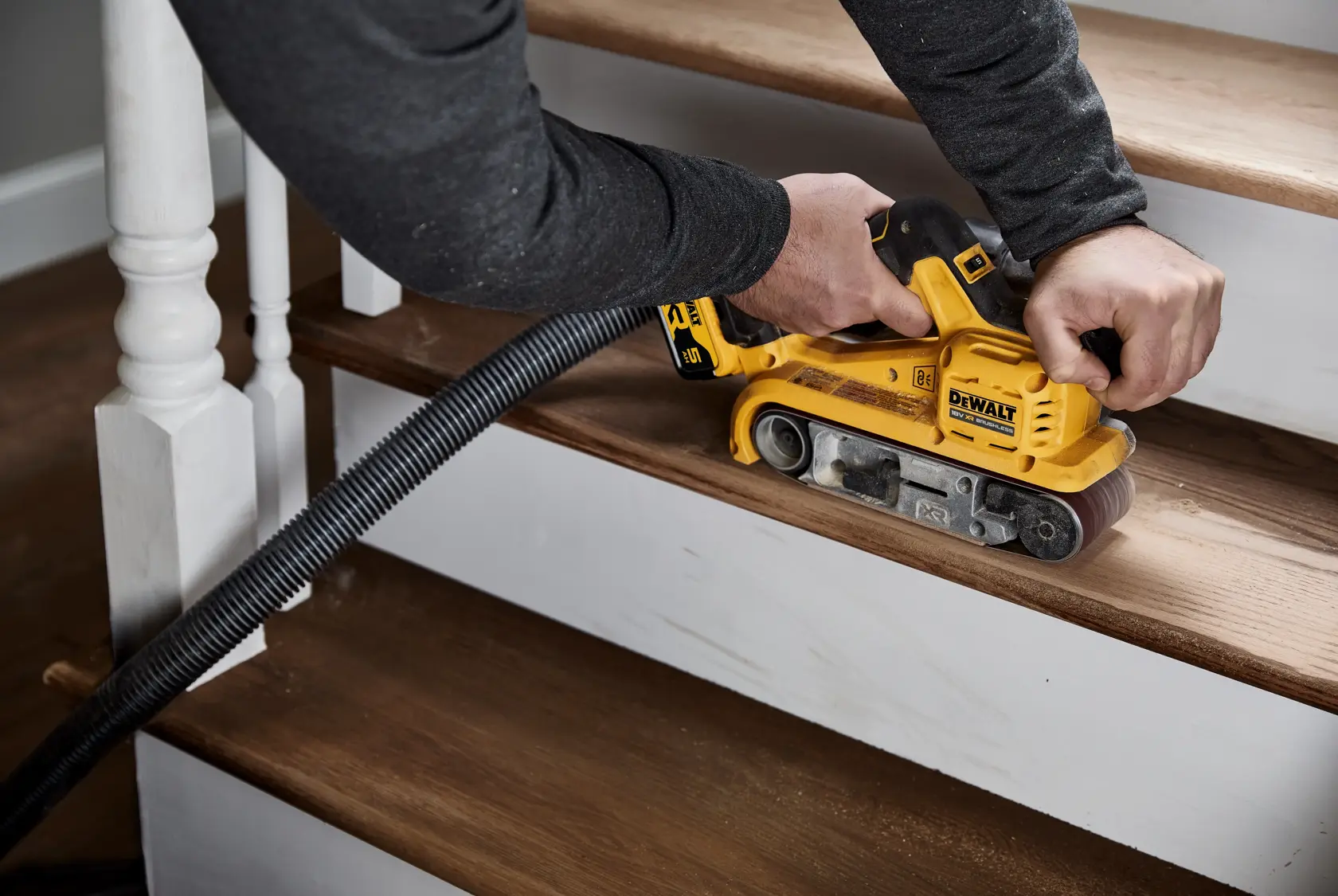 Cordless DEWALT belt sander with brushless motor and 18V battery, designed for sanding wood surfaces.