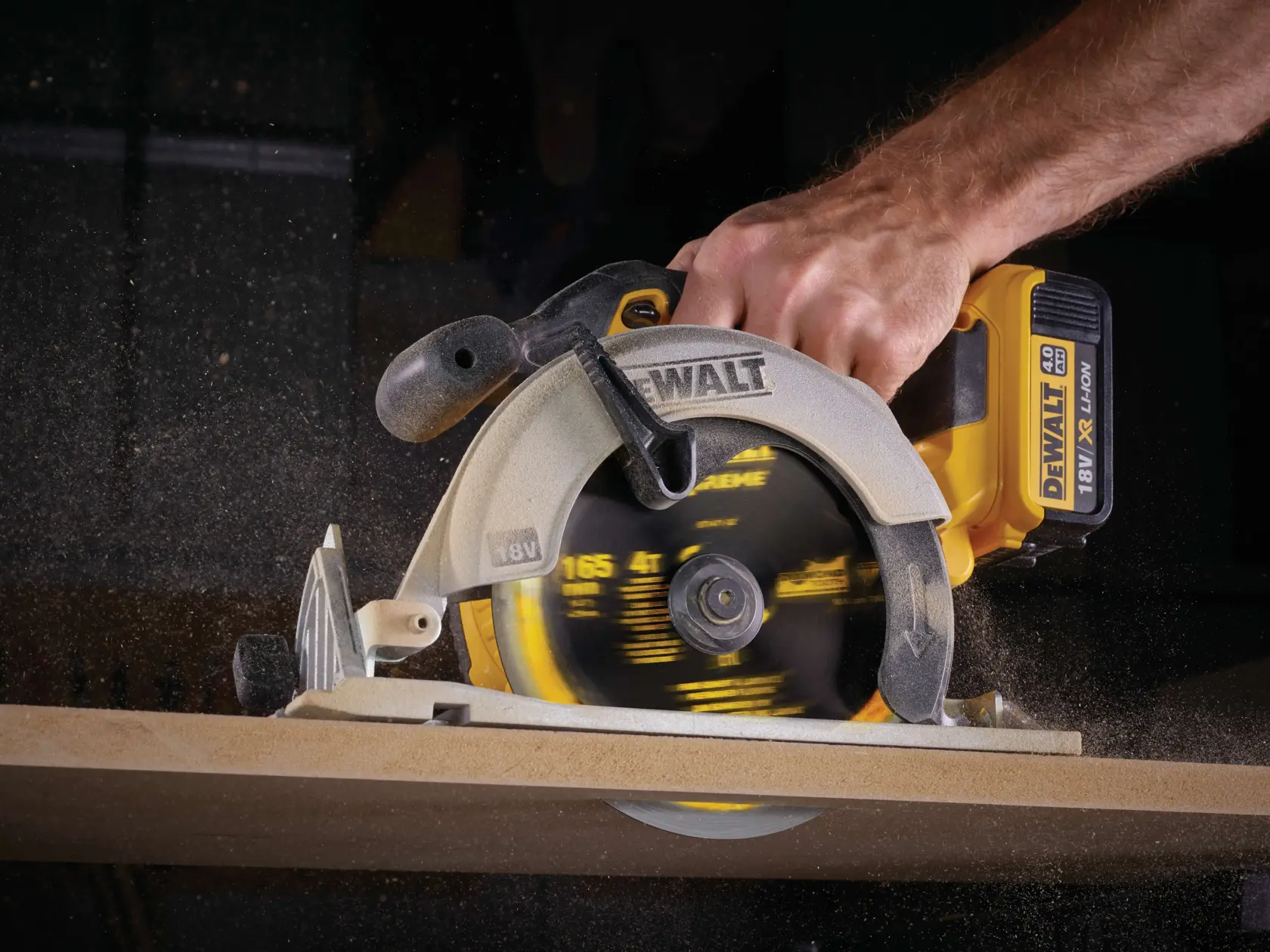 Sega circolare DEWALT a batteria taglia legno, dettaglio mano e lama in azione.