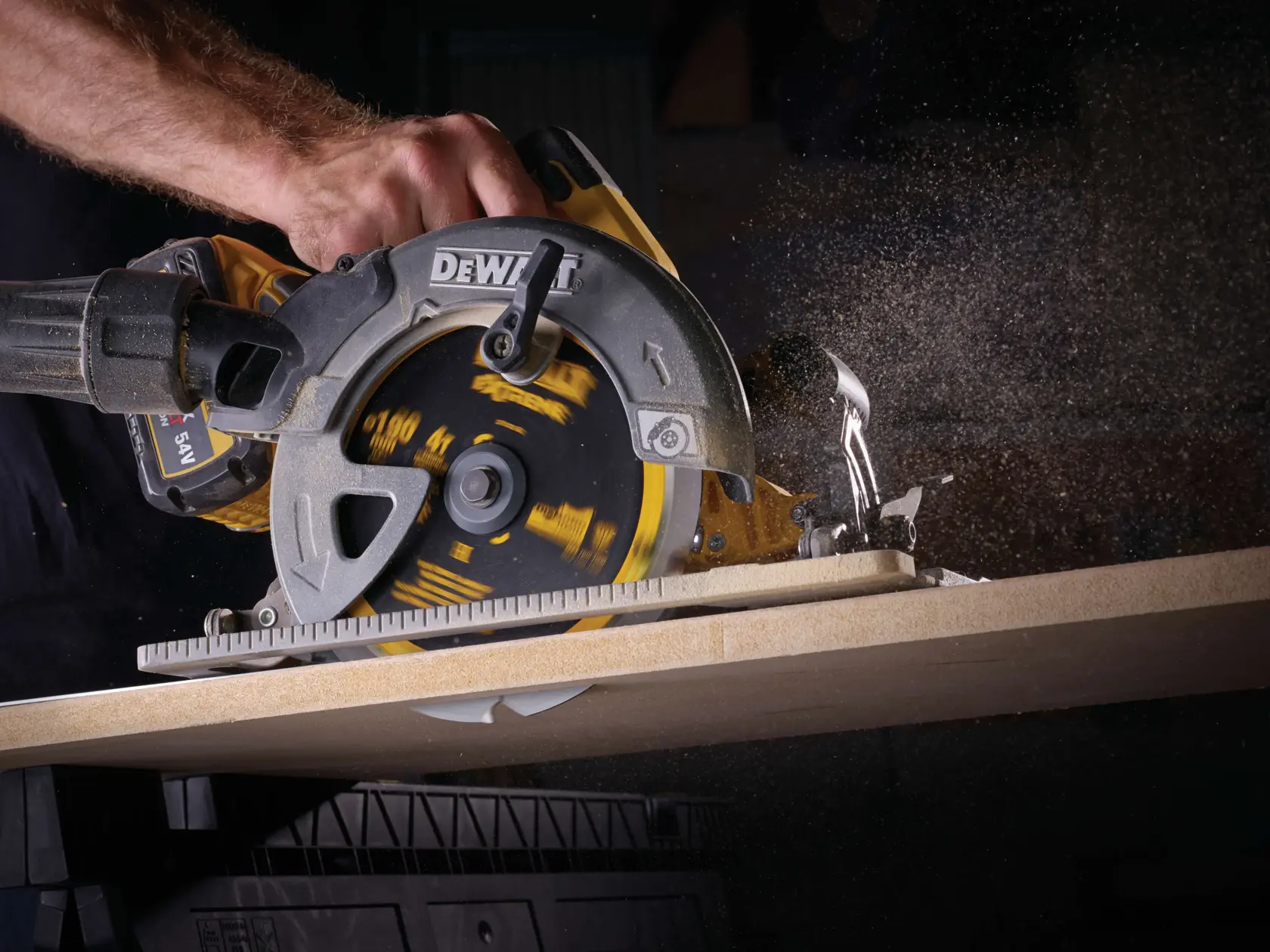 Primo piano di una sega circolare DEWALT che taglia il legno con polvere sospesa.