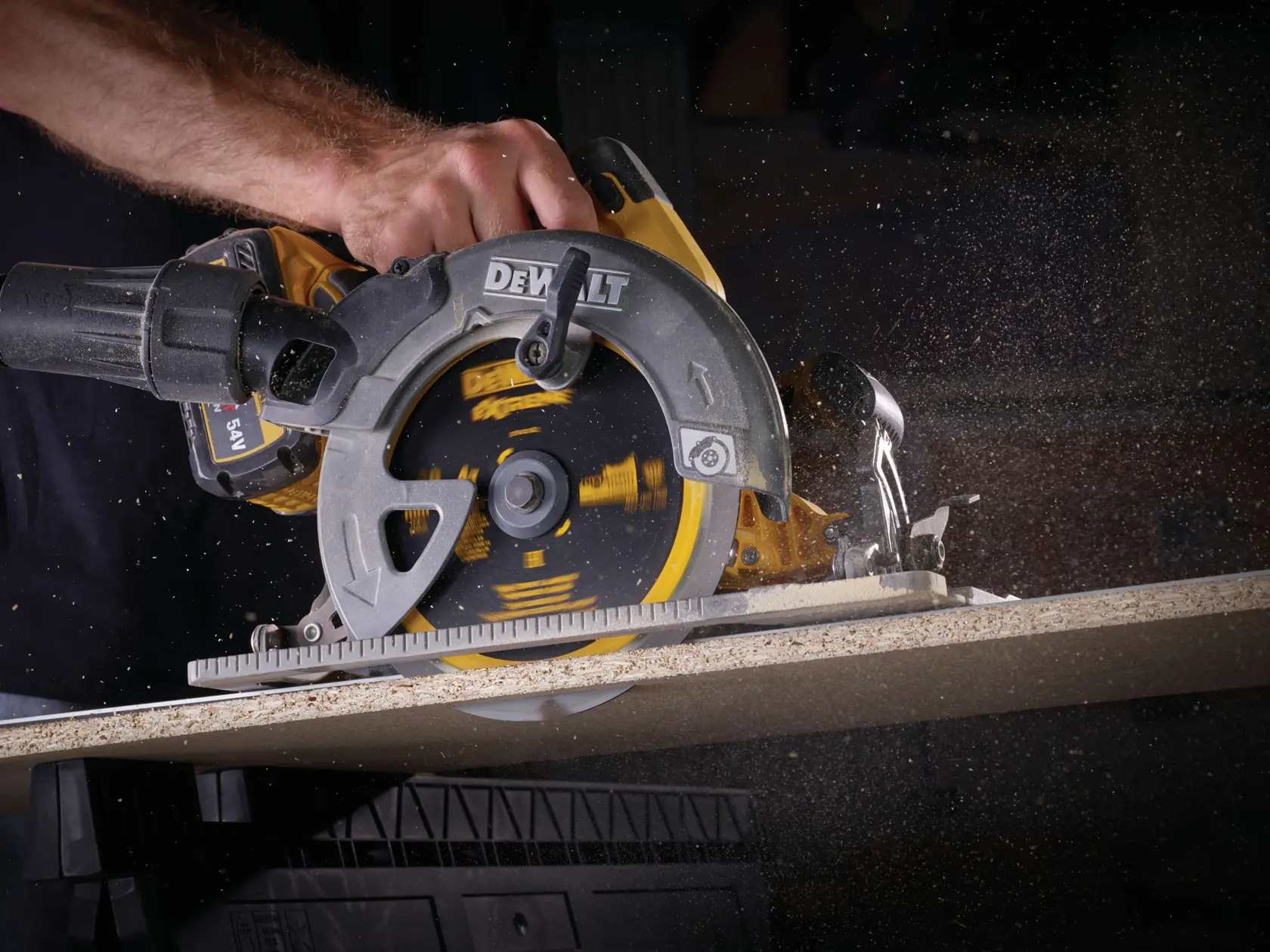 Una sega circolare DEWALT taglia il legno, con polvere che vola mentre la lama gira.