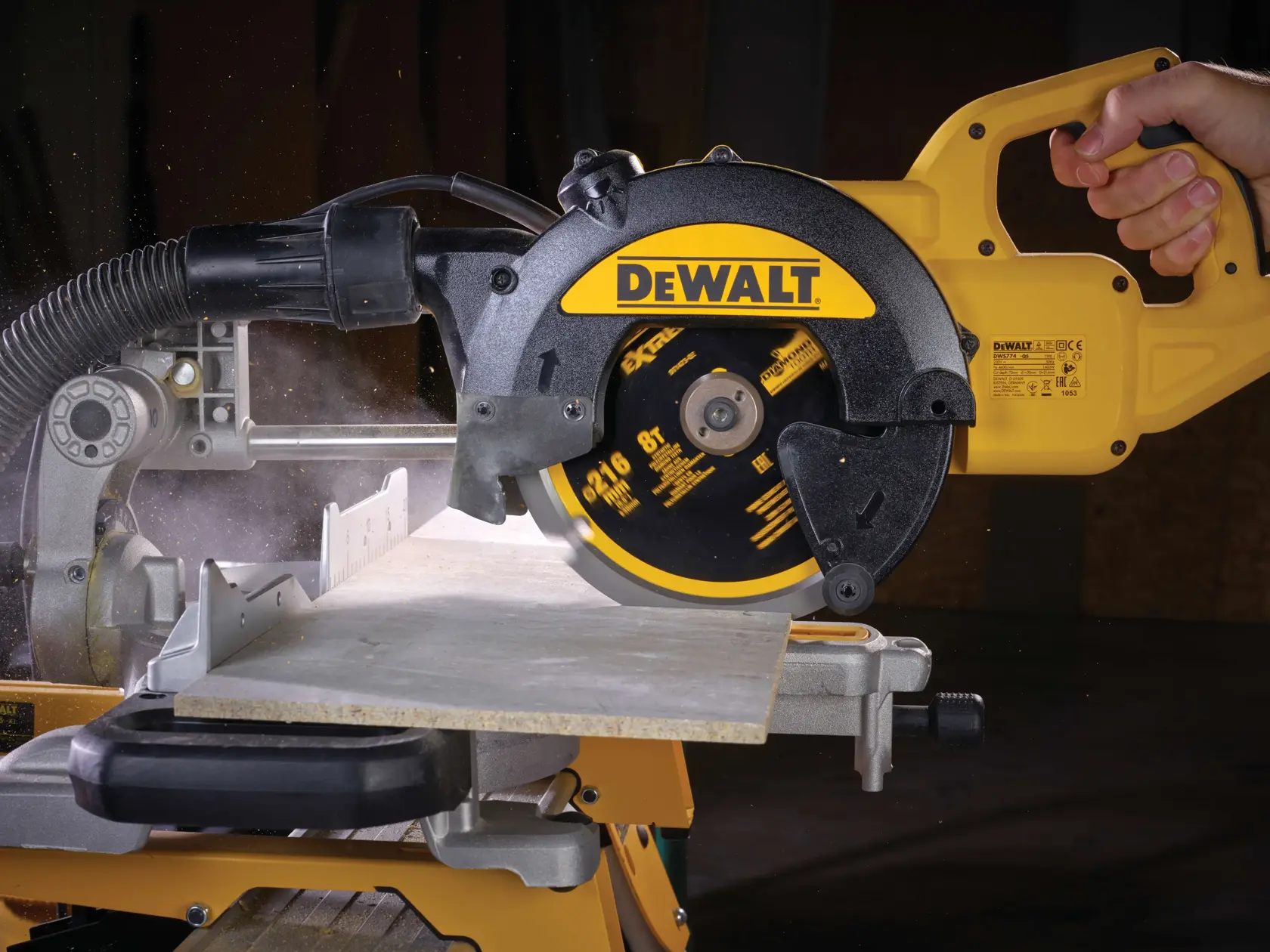 Sega circolare DEWALT taglia legno, tenuta in mano, con polvere e azione.