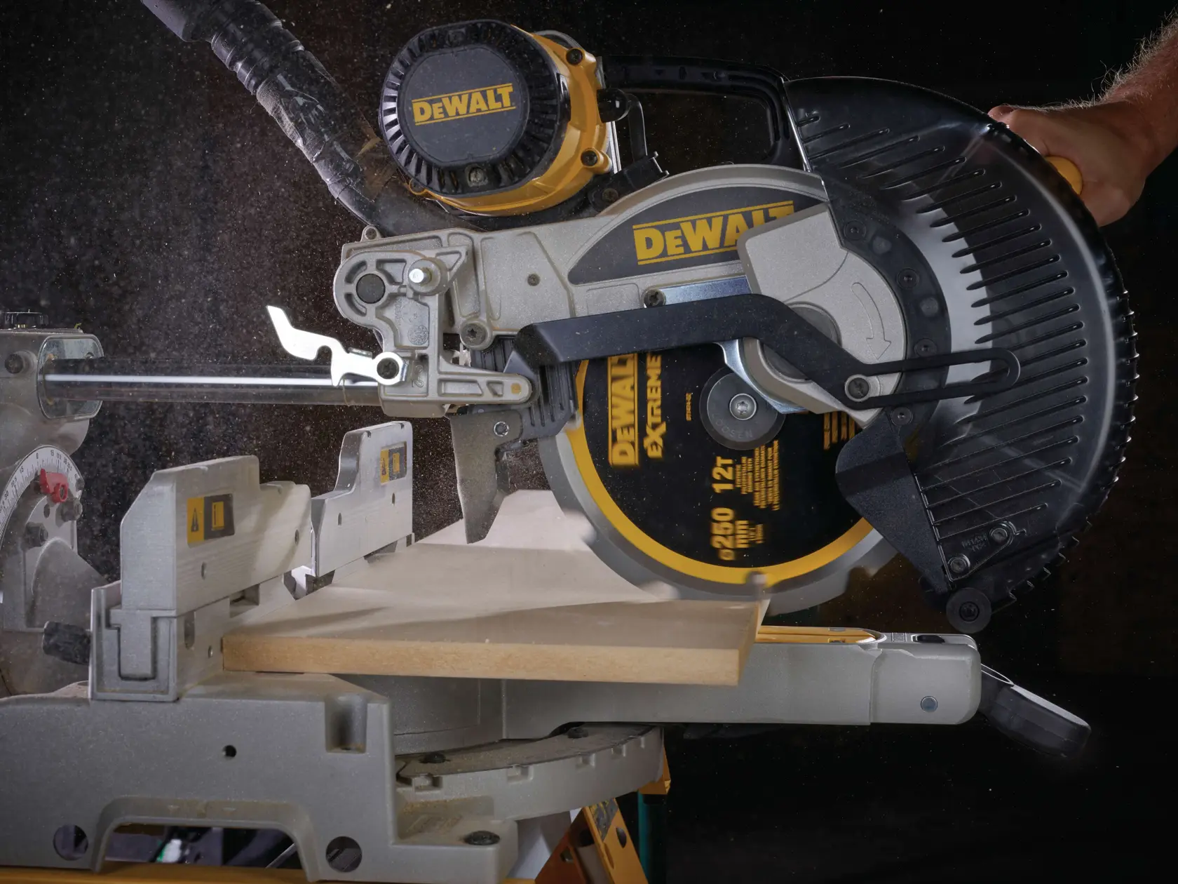 Sega circolare DEWALT taglia una tavola di legno, polvere visibile durante l’uso.