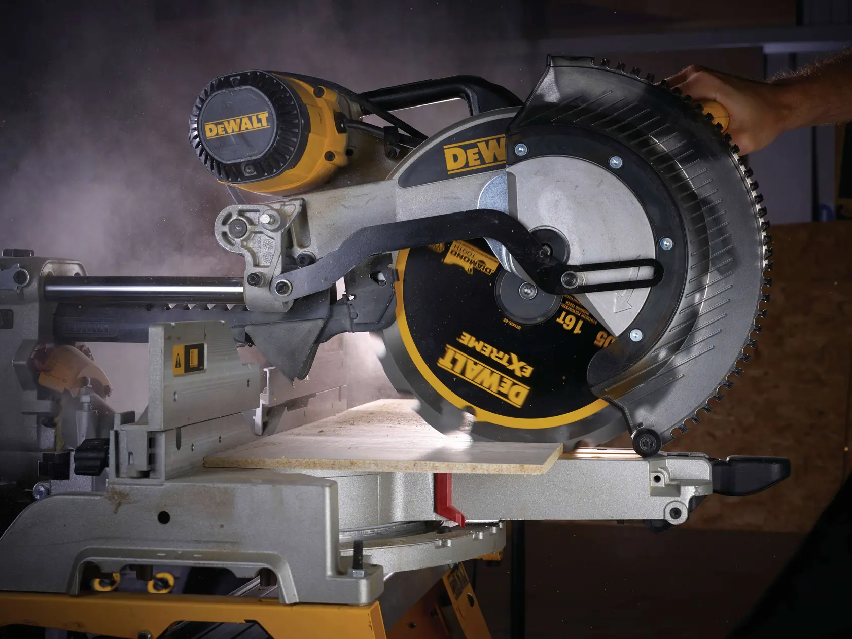 Sega circolare DEWALT taglia legno, polvere visibile, dettaglio lama e mano sulla maniglia.