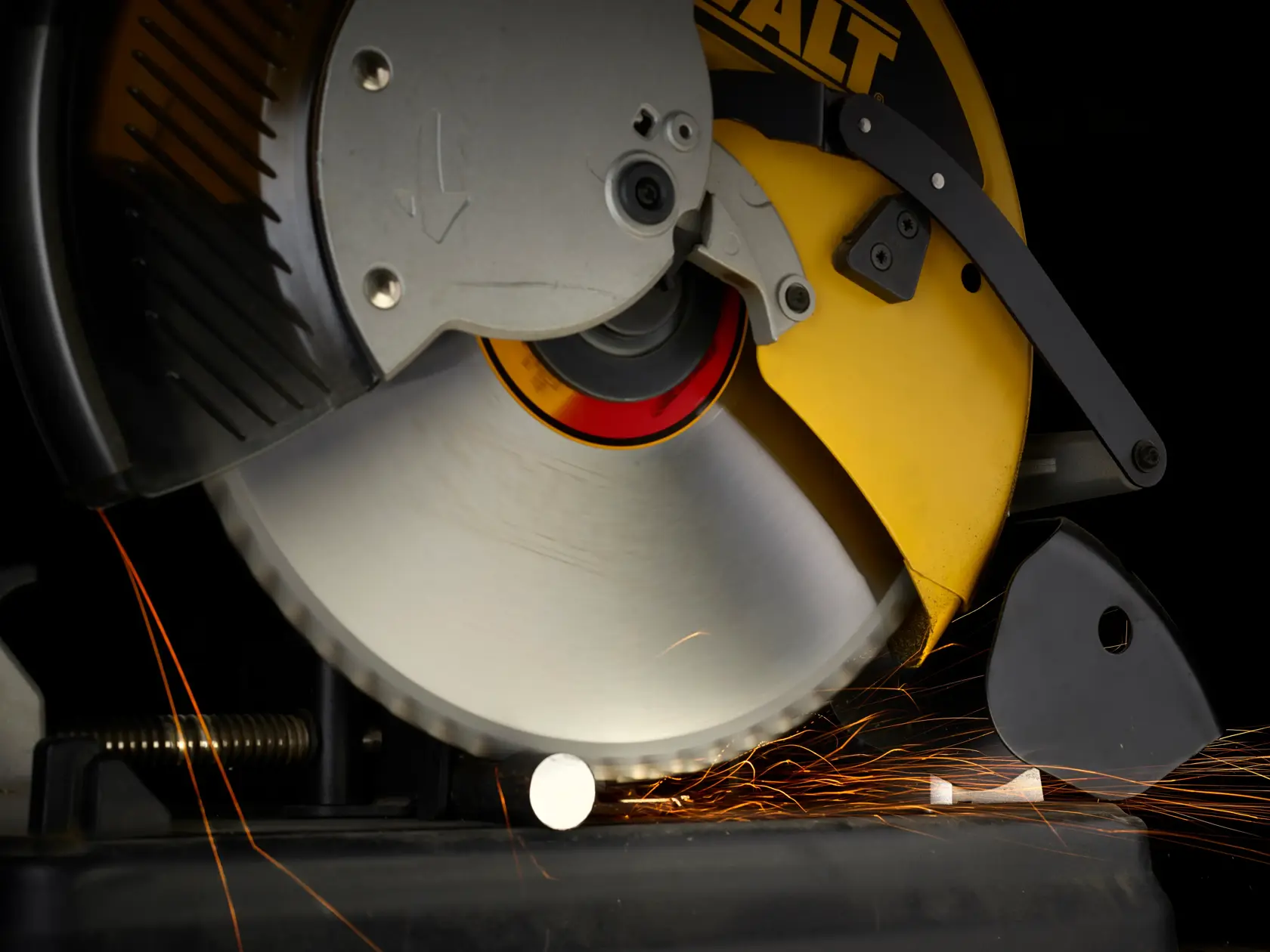 Close-up of DEWALT circular saw cutting metal, producing sparks.