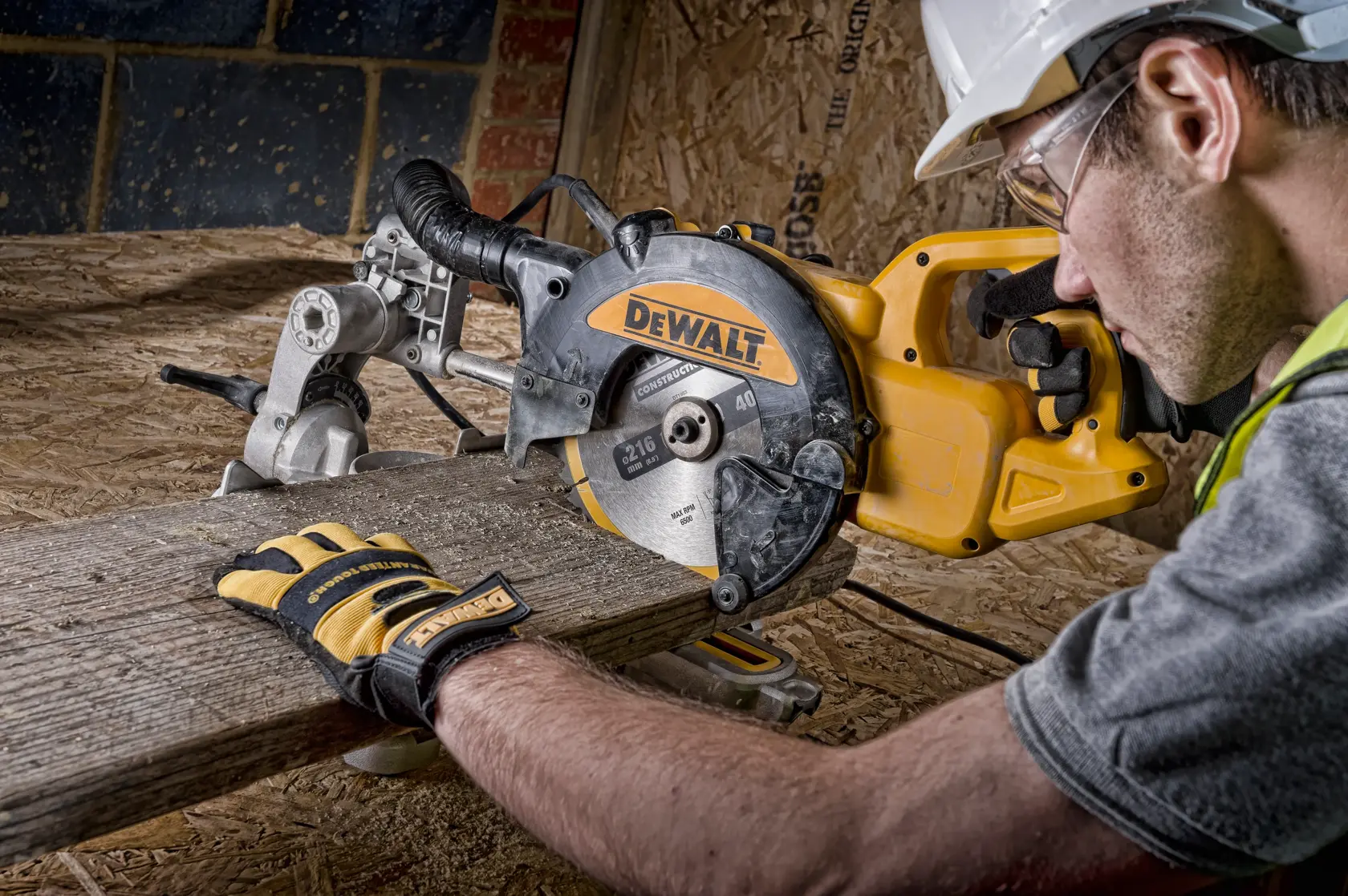 Sega a troncatrice DEWALT taglia legno, usata da persona con guanti e casco in cantiere.
