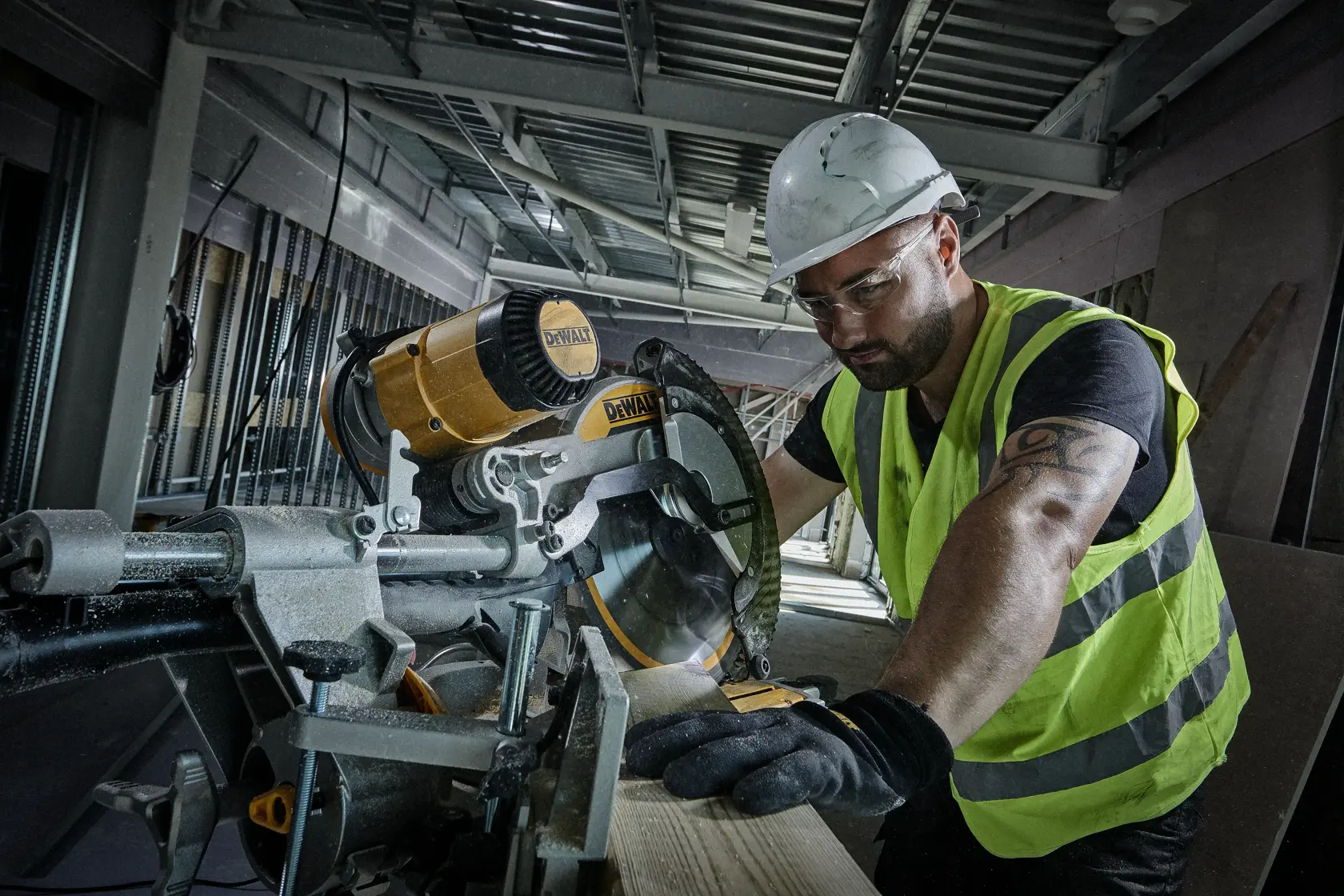Operaio taglia legno con sega circolare DEWALT in cantiere, indossa gilet ad alta visibilità.