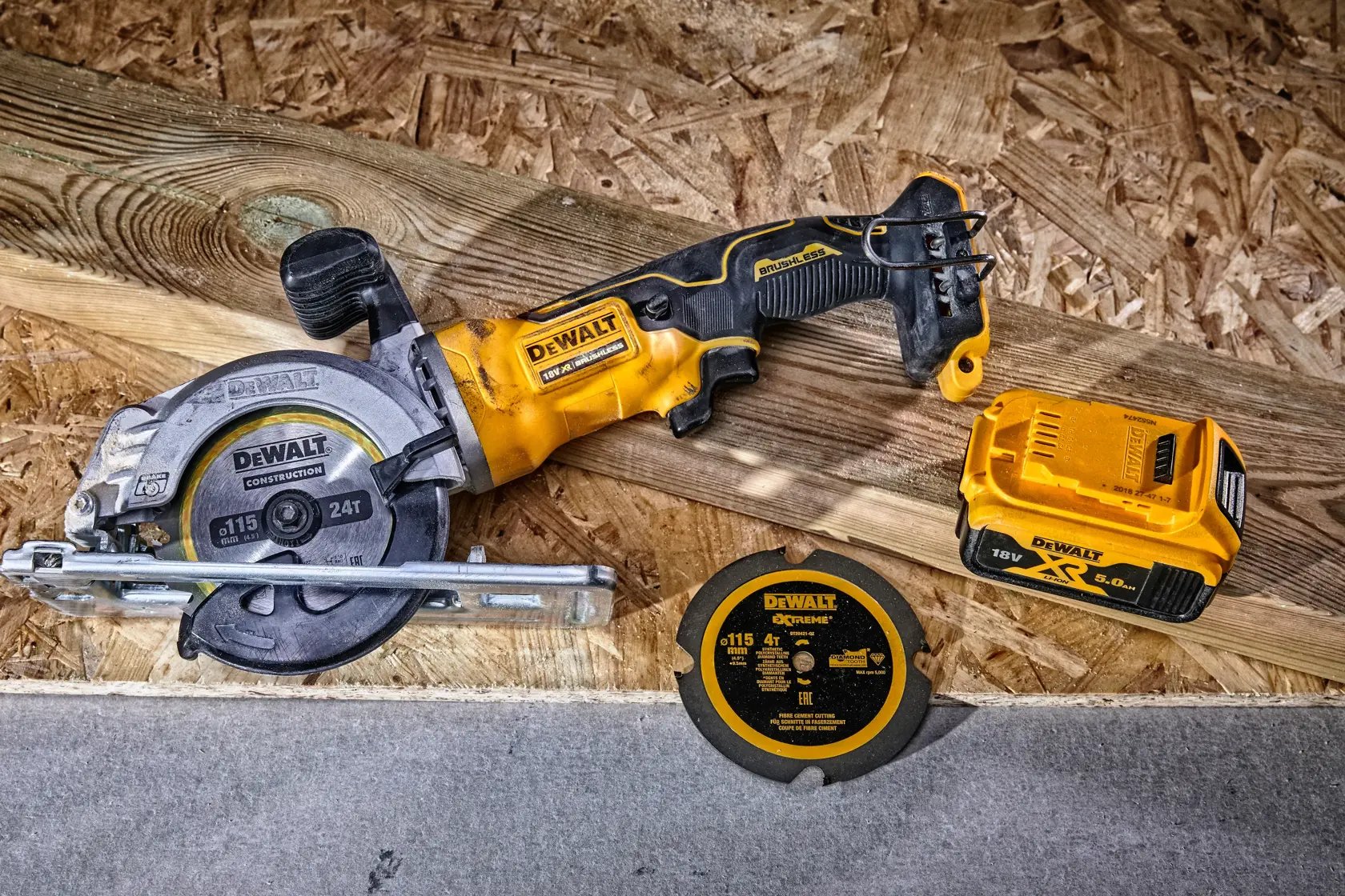 Sega circolare a batteria DEWALT con lama, disco di ricambio e batteria su tavola di legno.