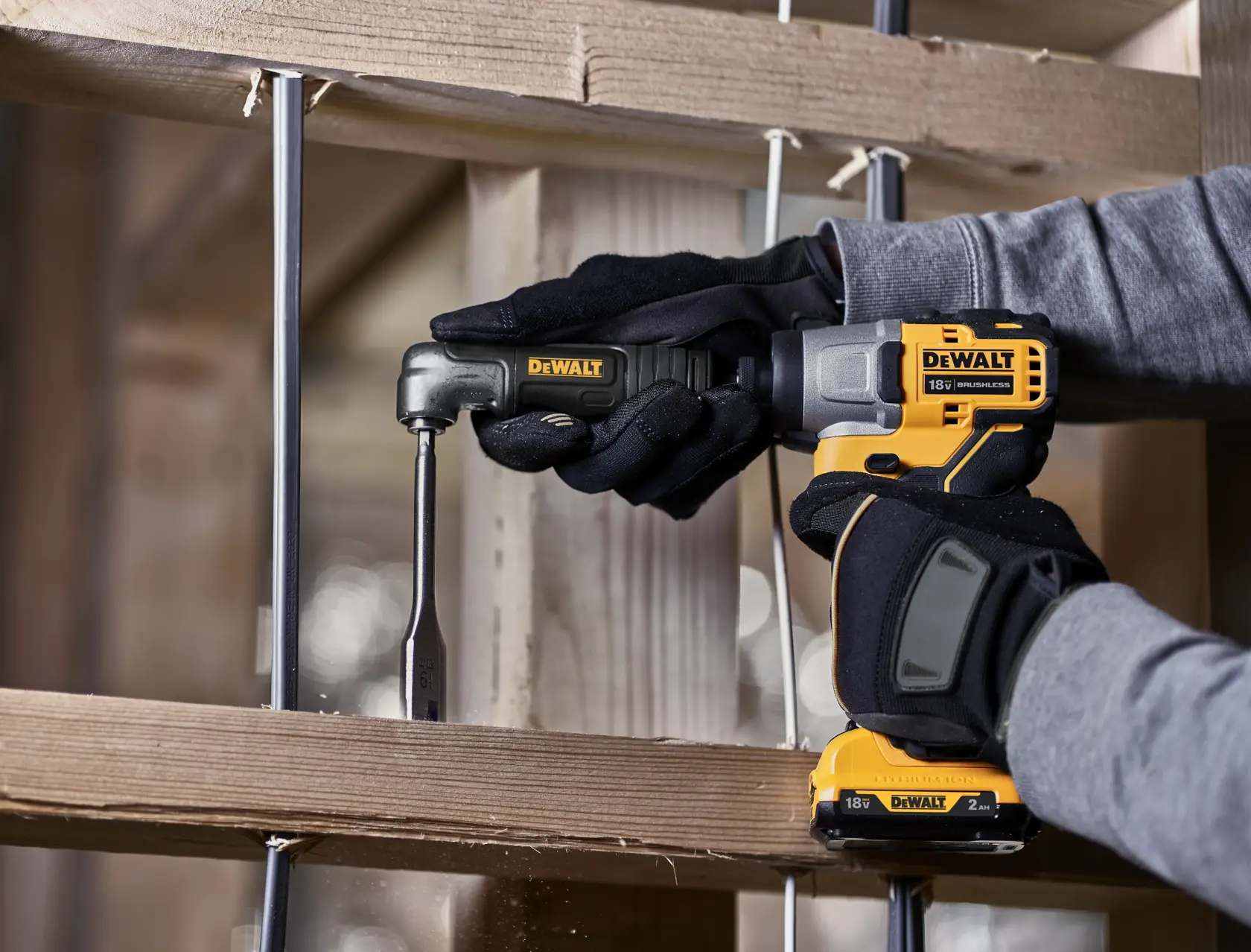 DEWALT 18V drill in use with an attachment, drilling into wood in a construction setting.