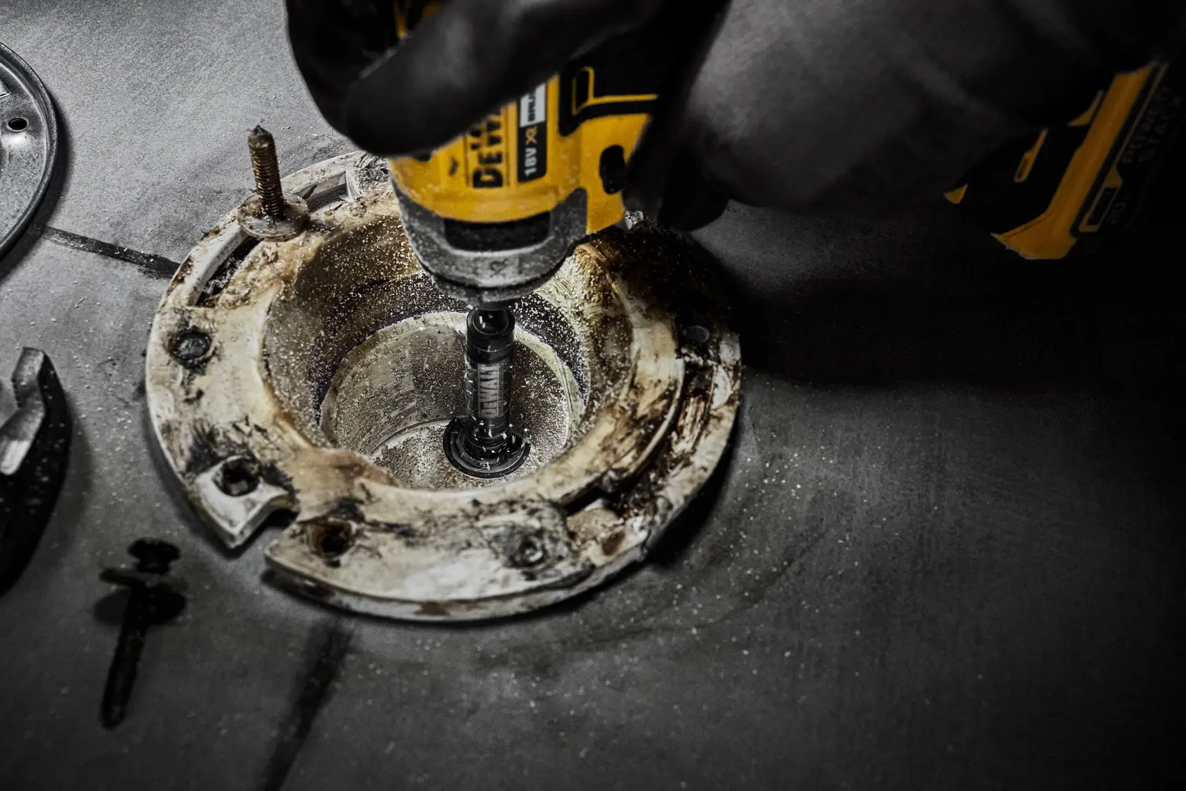 DEWALT tool used for drilling or grinding inside a circular metal fixture on a work surface.