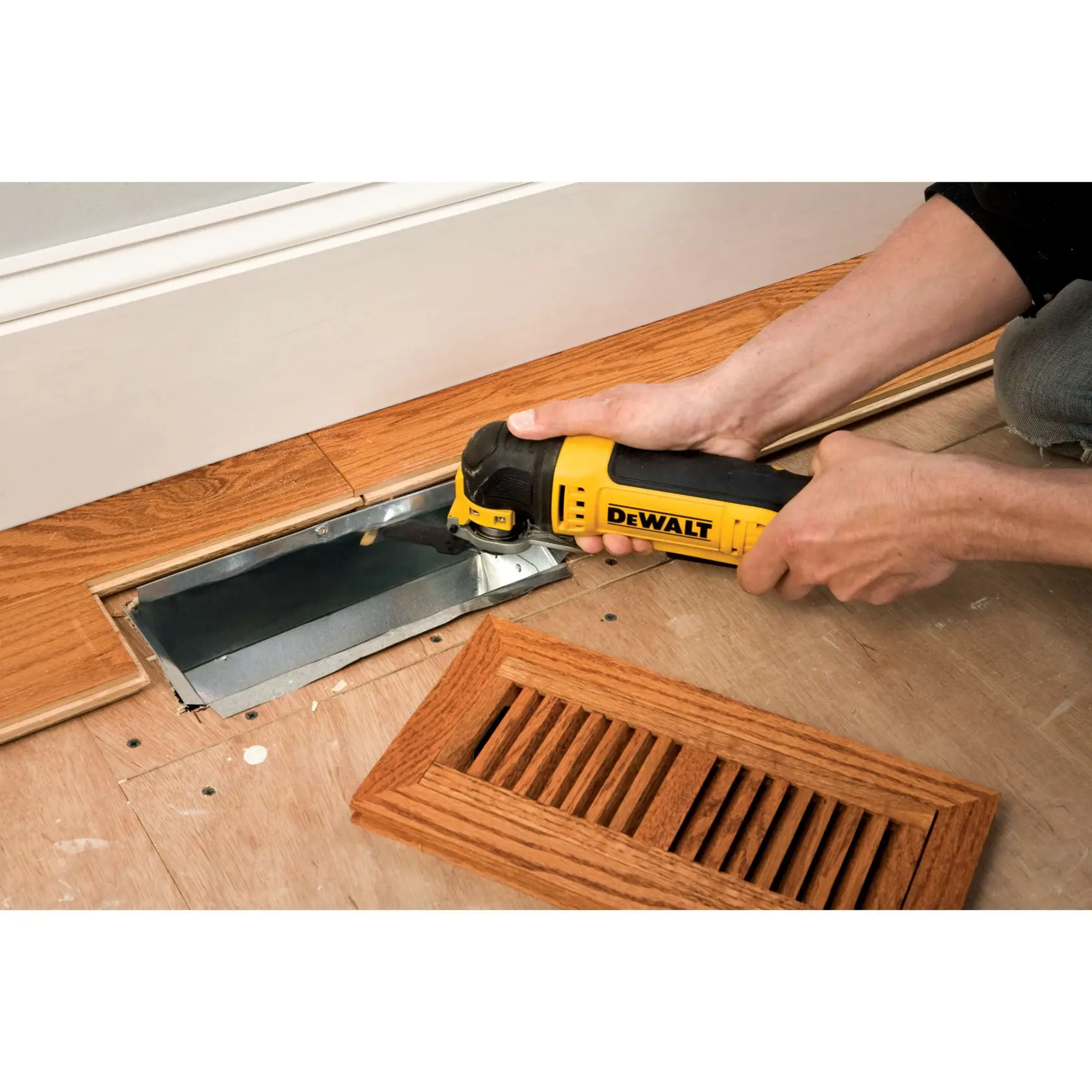 DEWALT DT20702 tool used to cut wood floor near a vent opening, wood vent cover is placed beside.
