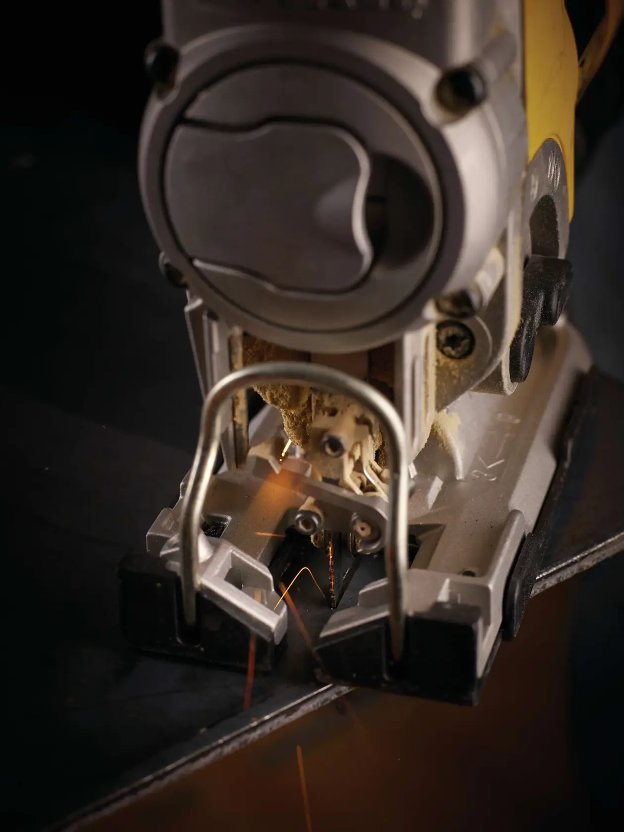 Close-up of a DEWALT jigsaw cutting metal, with sparks visible near the blade.