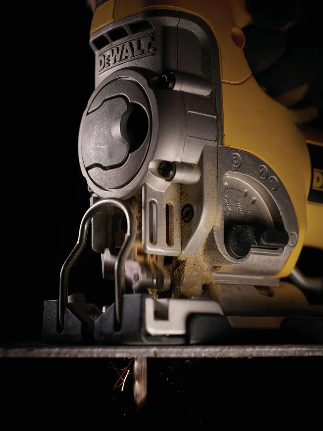 Close-up of a DEWALT jigsaw in use, cutting material. Tool details and blade are visible.