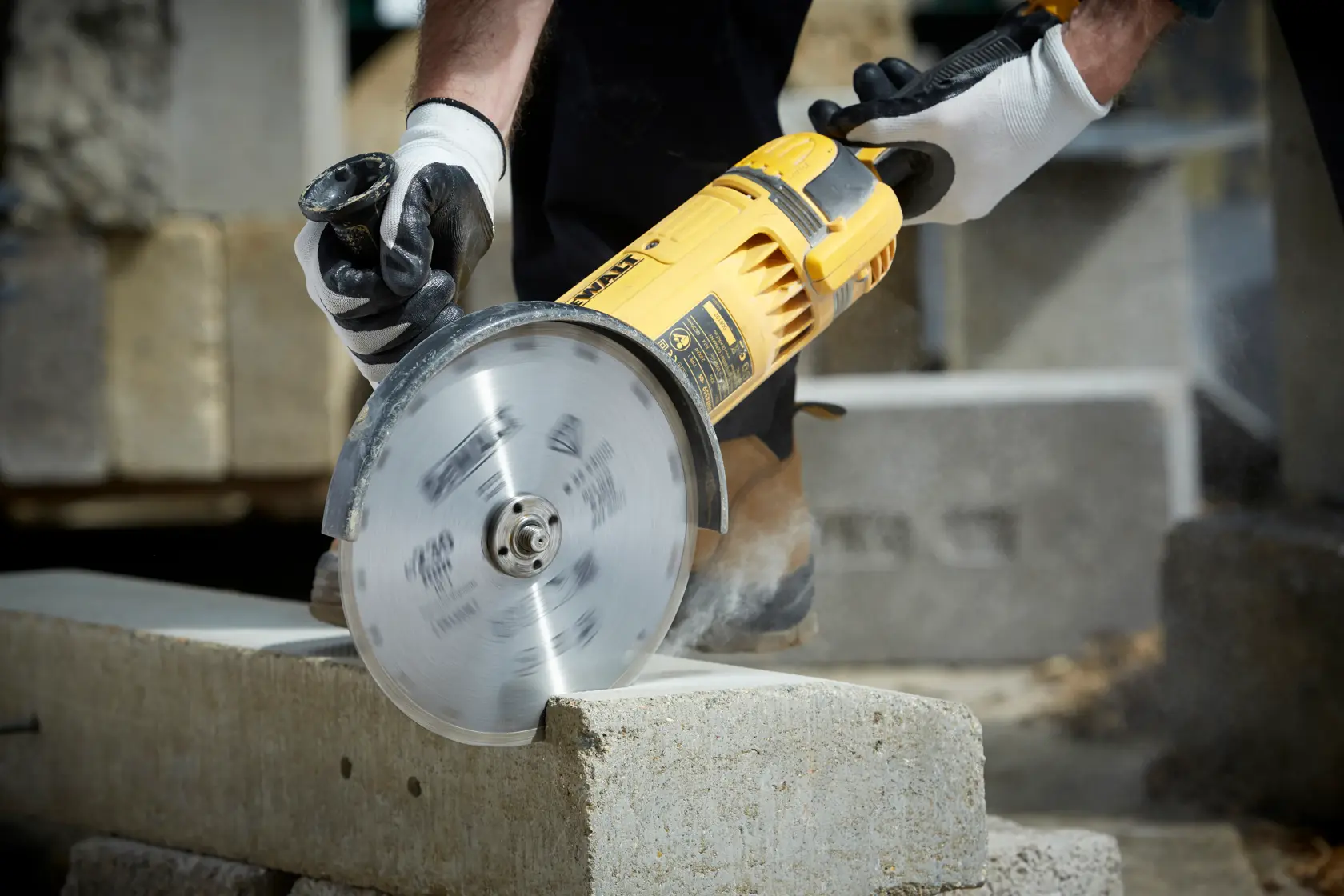 DEWALT DT3731 corta bloque de concreto, operado por manos con guantes en construcción.