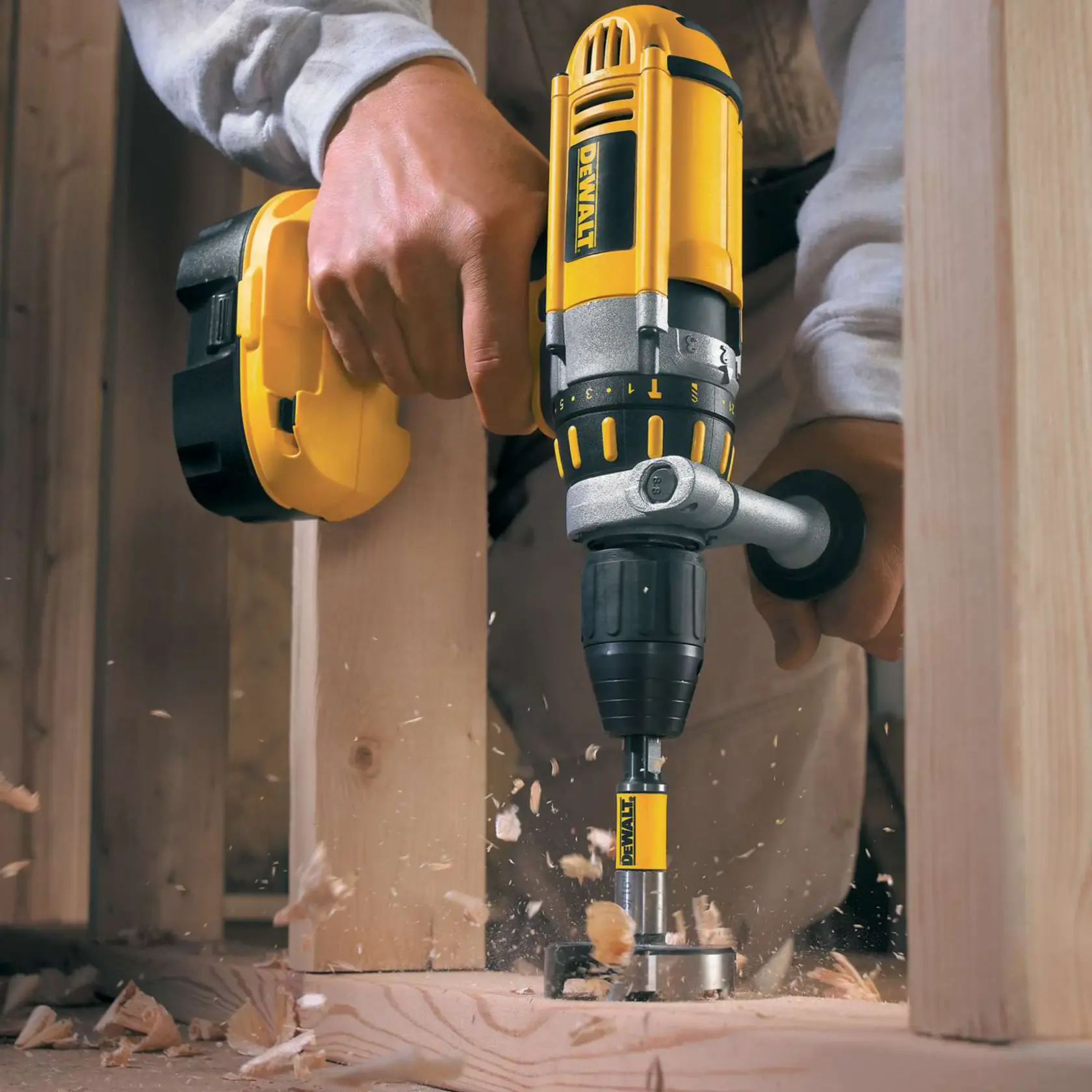 Trapano DEWALT in azione sulla trave di legno, trucioli volano fuori dal taglio.
