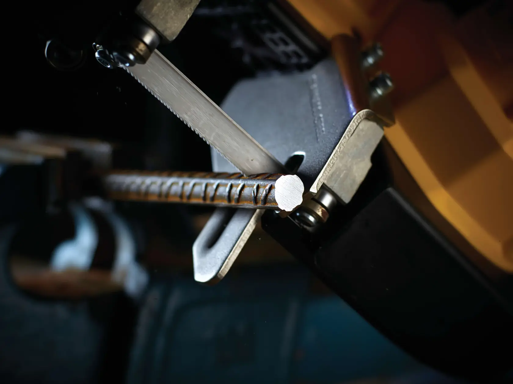 Primo piano di una sega DEWALT che taglia una barra metallica in officina.