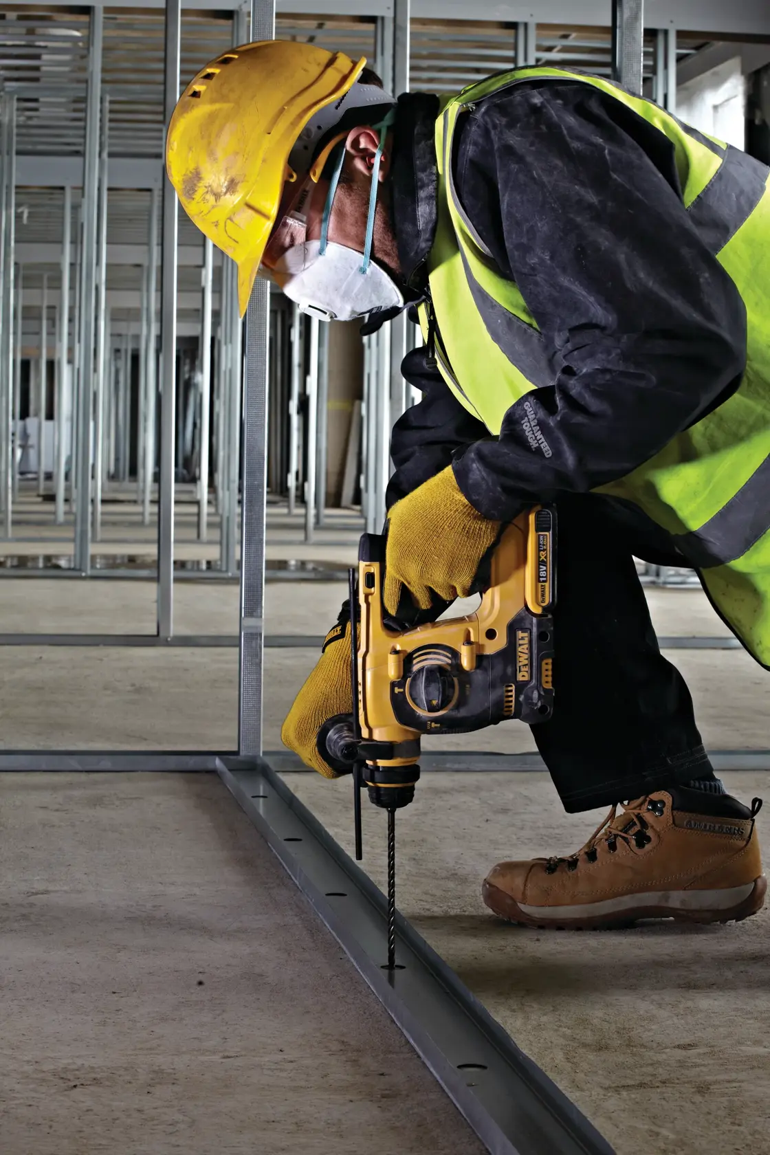 DEWALT drill making a hole in concrete stairs at a construction site.