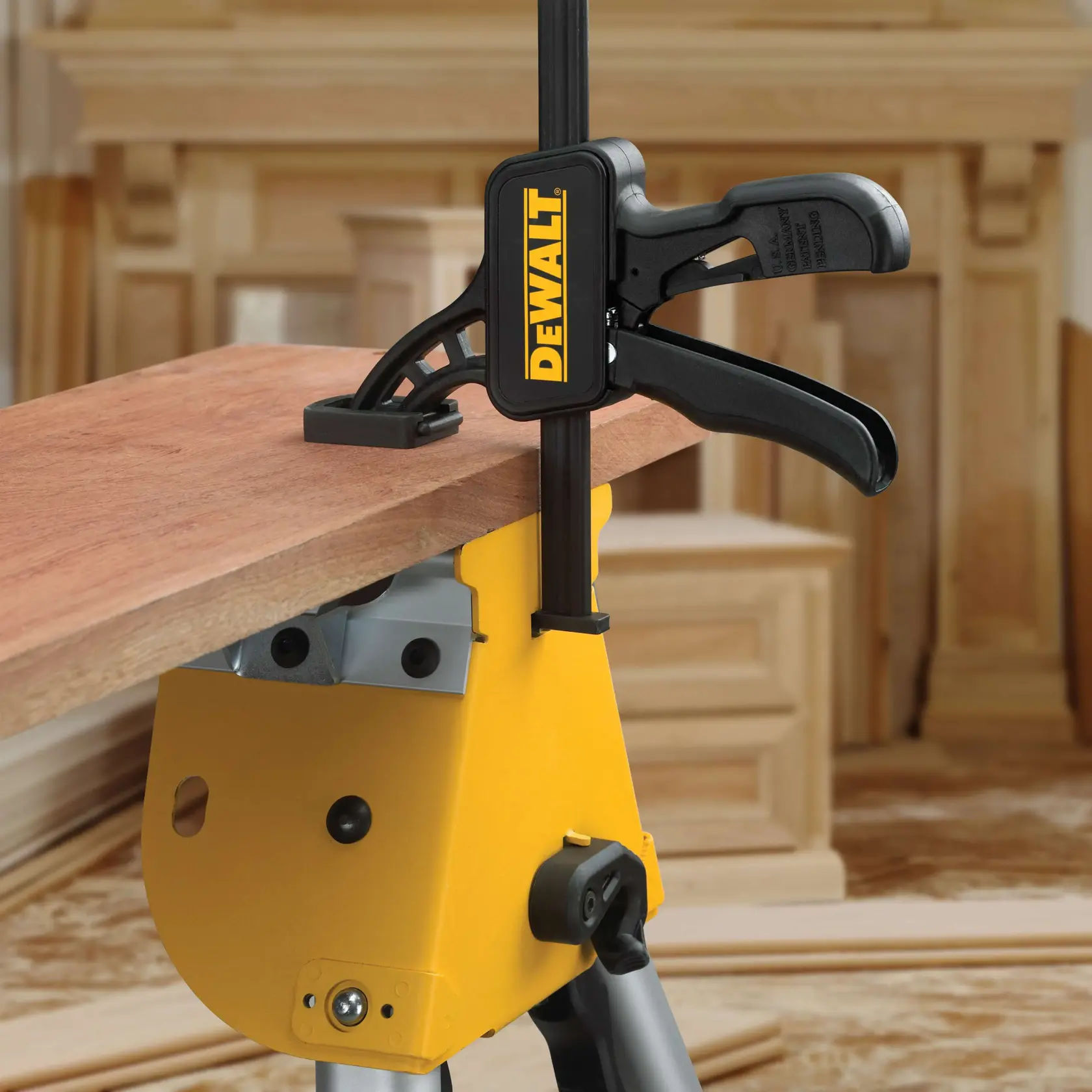 Morsetto DEWALT fissa una tavola su una postazione gialla in officina.