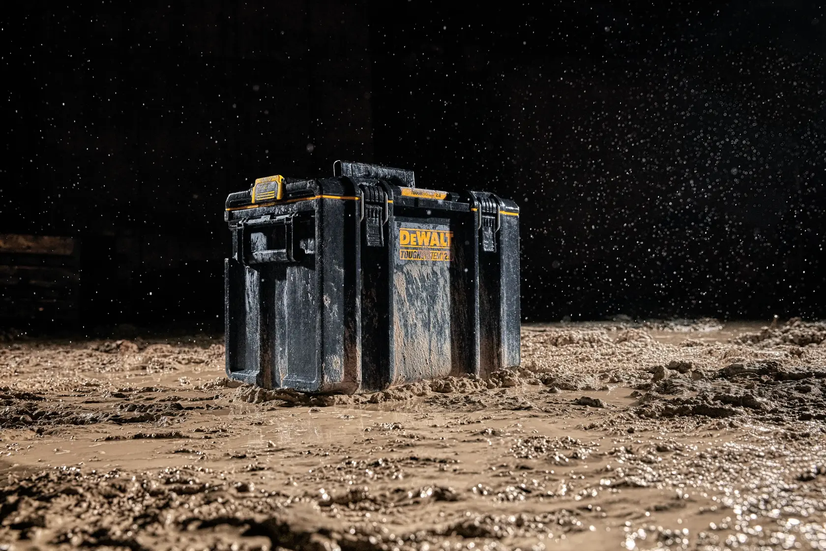 DEWALT DWST83342-1 tool box shown in muddy conditions with water splashing, highlighting durability.