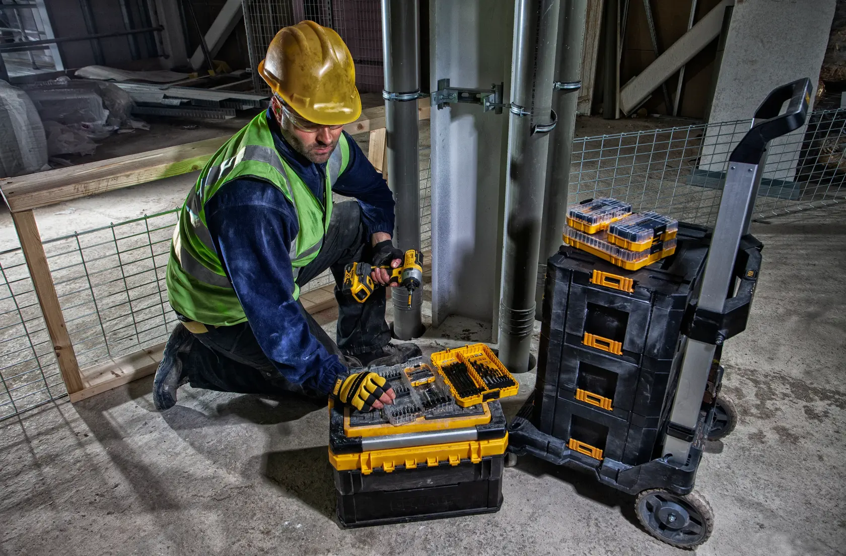 DEWALT DWST83454-1, DWST1-71196, DT70758 tool storage used at worksite. Photography category. Worker kneeling.